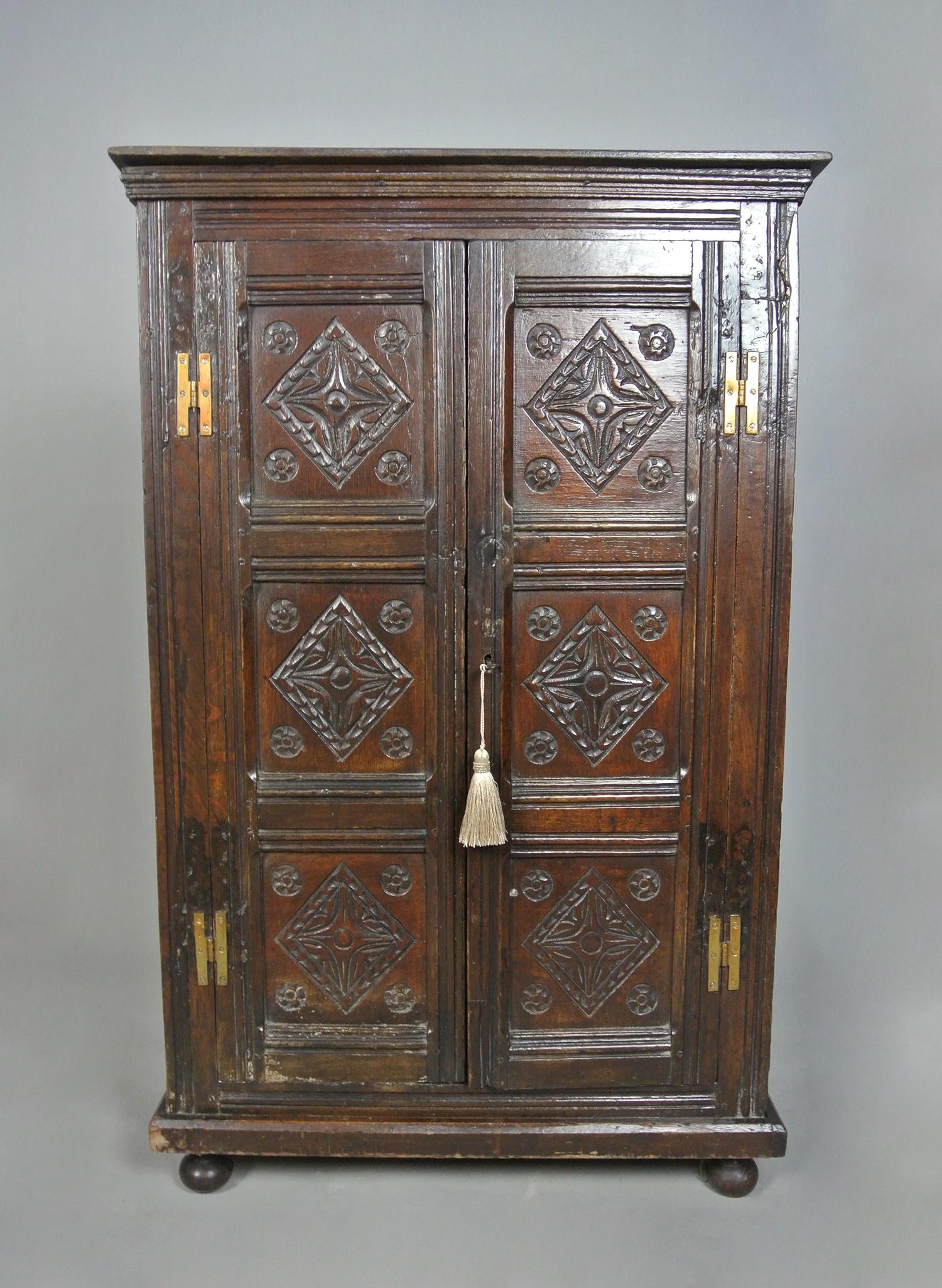 A rather unusual small oak livery cupboard or child’s cupboard being only 41 inches high, 26 inches wide and 12 inches deep.

Beautiful rich colour to the oak and each of the three fielded panels to each door are well carved with lozenge with