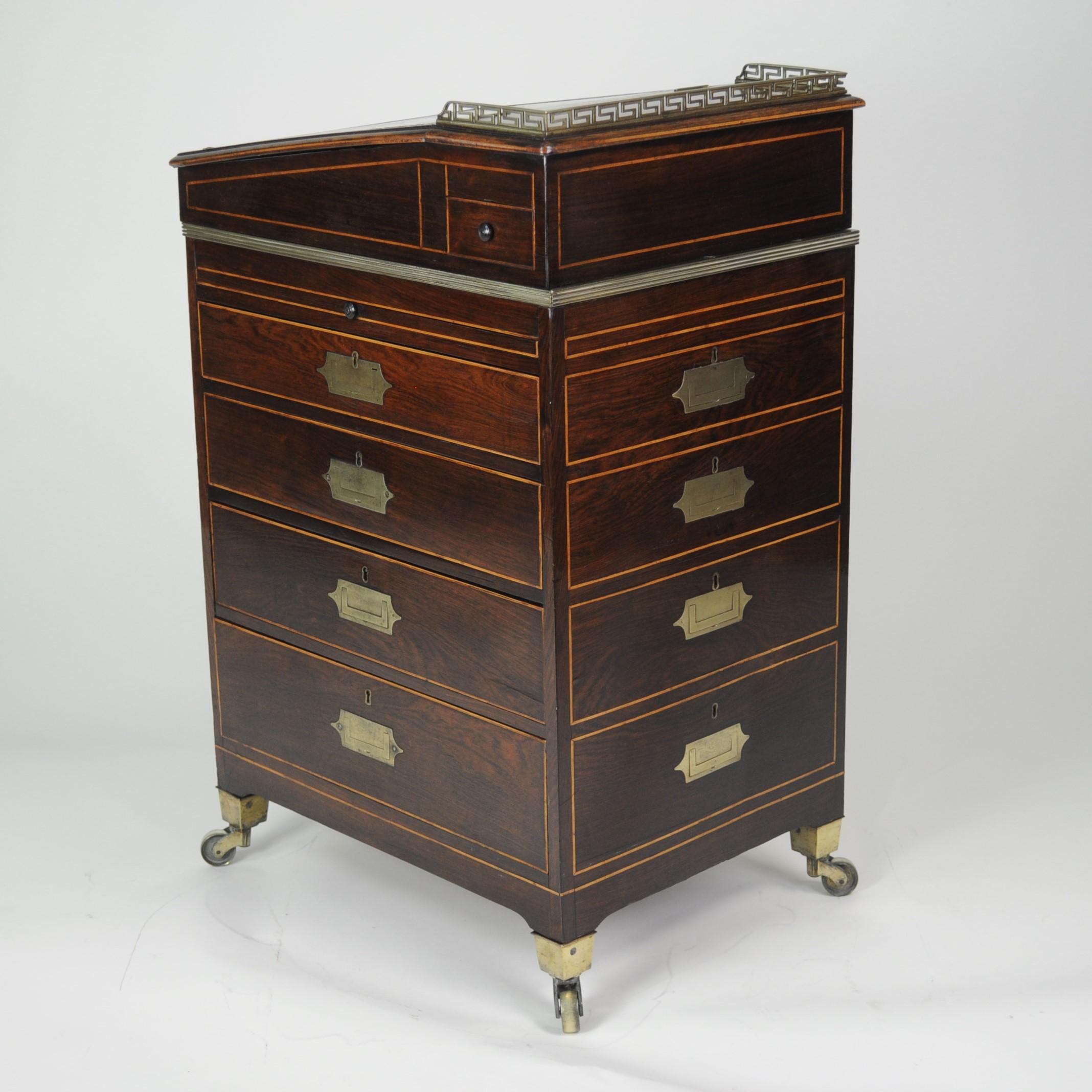 A small and rare rosewood campaign Davenport desk of compact proportions. The galleried top with leather-lined writing surface opening to real a fitted interior, above a bank of four drawers which pull-out from the right side, but are replicated on