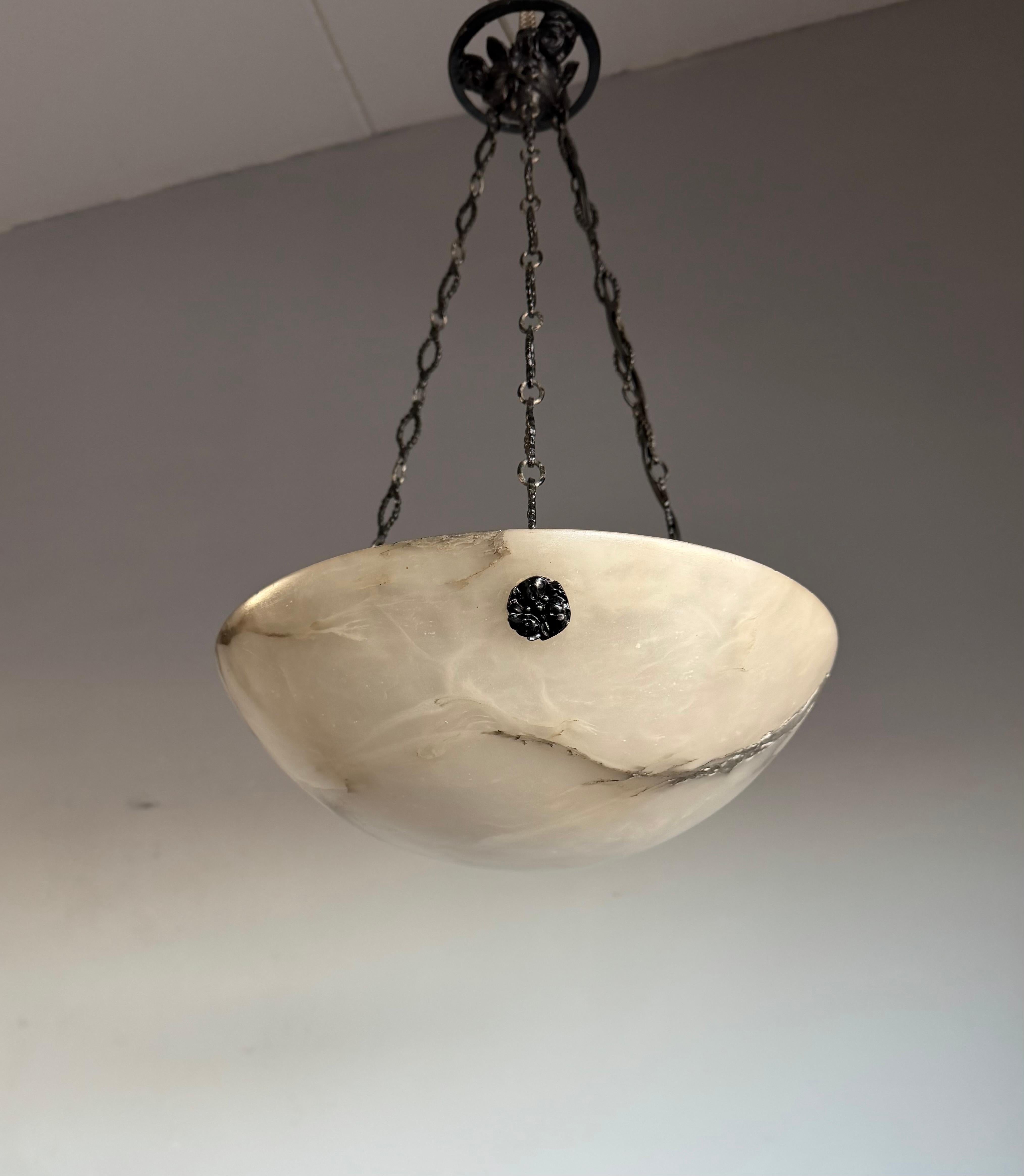 Petit lustre dôme Art Déco vraiment intemporel qui ne manquera jamais d'impressionner.

L'éclairage du début du XXe siècle étant l'une de nos spécialités, la découverte d'un luminaire en bon état (seulement une fissure naturelle en forme de veine,