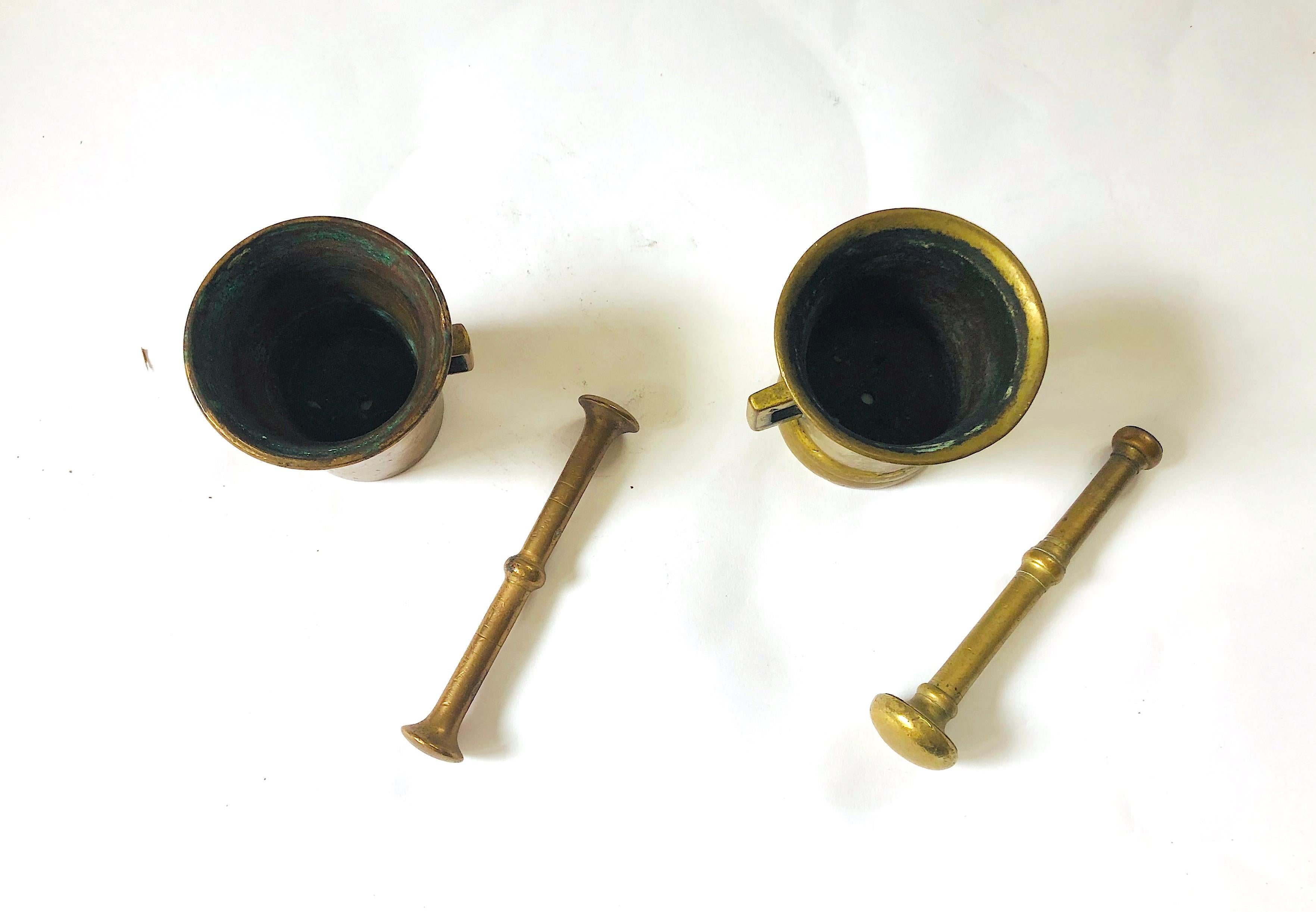 Set of 2 very cool heavy brass (?) antique mortar and pestles. Actually one may be brass and one copper, judging from the green aging tinge inside. They are not a matched set but very similar in size and shape, both with handles. 

Lovely as decor.