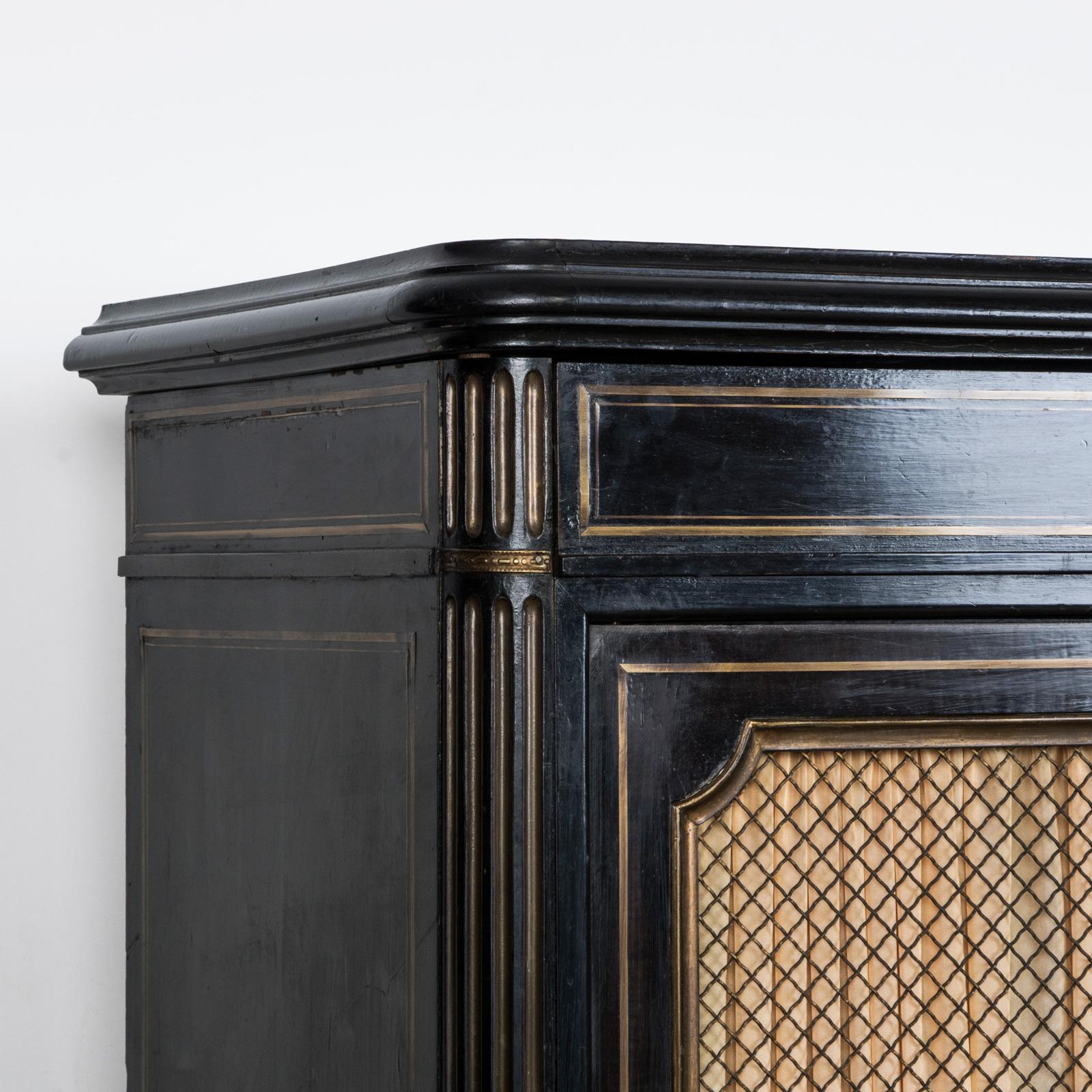 Charming and aesthetic small ebonized black cabinet with brass accents, dating back to the 19th Century in the French Napoleon III style.

This ebonized black cabinet features nice brass embellishments, showcasing a fusion of elegance. Originating