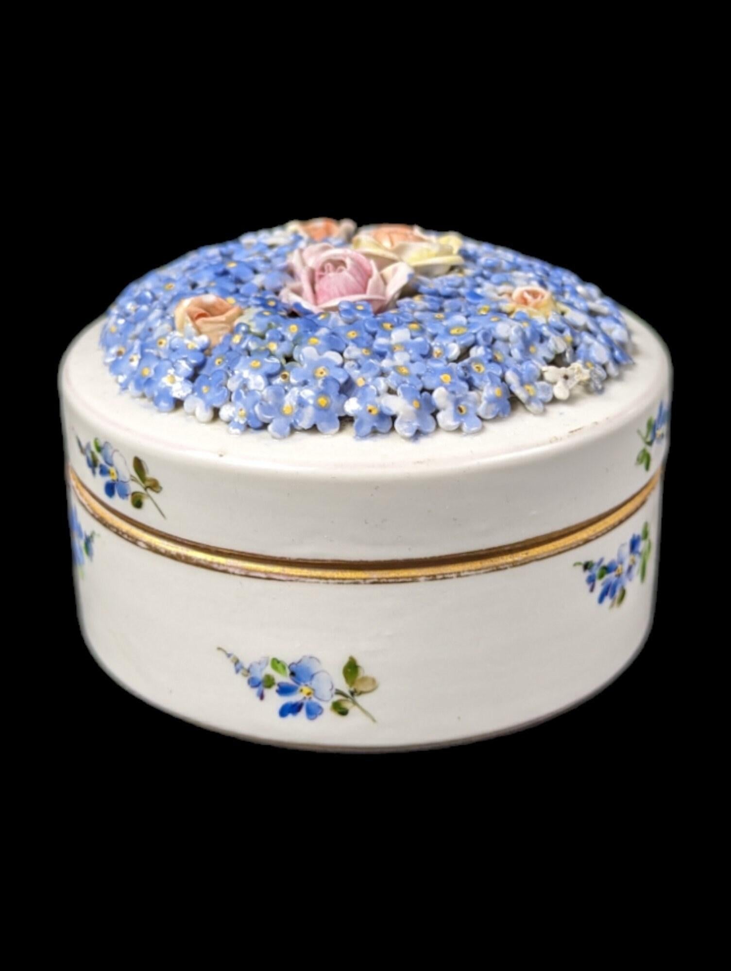 Questo charme Antiques piccolo del 19° secolo con fiori incrostati di porcellana Schierholtz è un delicato pezzo di storia, che mostra l'intricata maestria dell'epoca. Realizzato dalla rinomata fabbrica Schierholtz, nota per la sua porcellana di