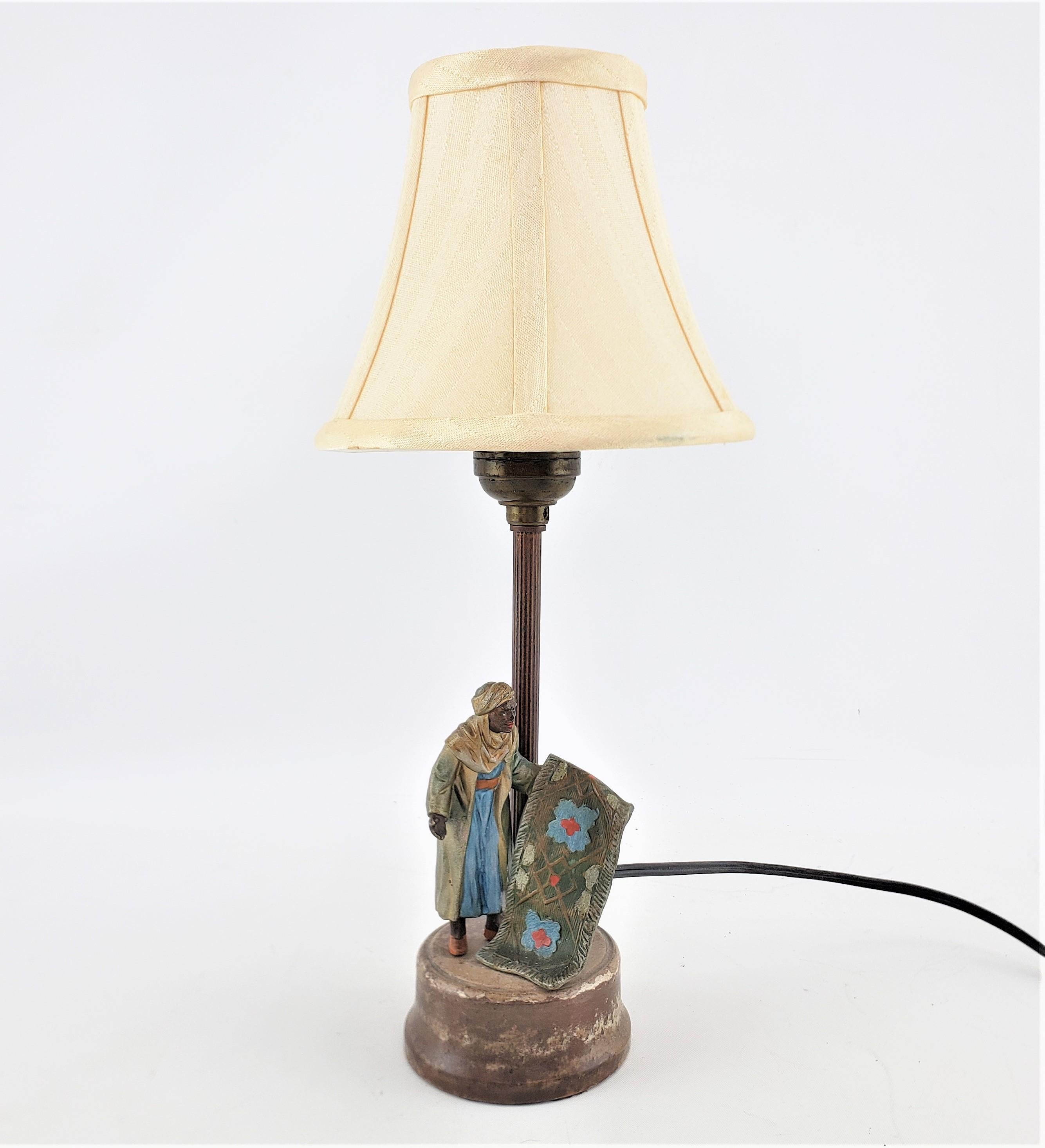 Diese kleine antike figurale Tischlampe ist unsigniert, stammt aber vermutlich aus Österreich und wurde um 1920 im Art-déco-Stil gefertigt. Der Sockel der Lampe besteht aus gegossenem Zinn, das im realistischen Stil kalt bemalt wurde. Die Figur