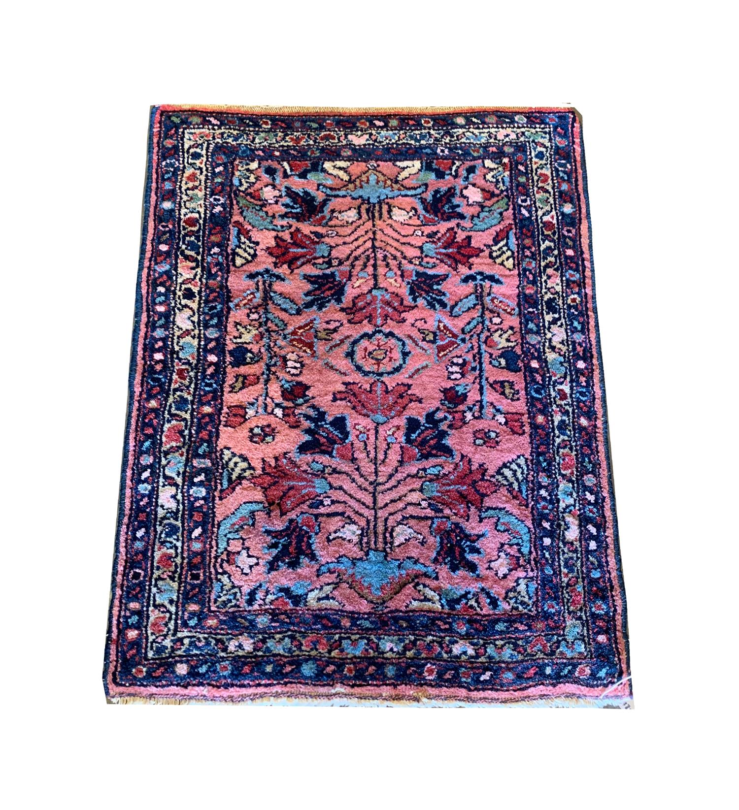 This fine wool rug was woven by hand in Azerbaijan country in the Caucasus region known for there bold design. The central design features a symmetrical floral pattern woven in blue, red, ivory on a pink background. This has then been framed by a