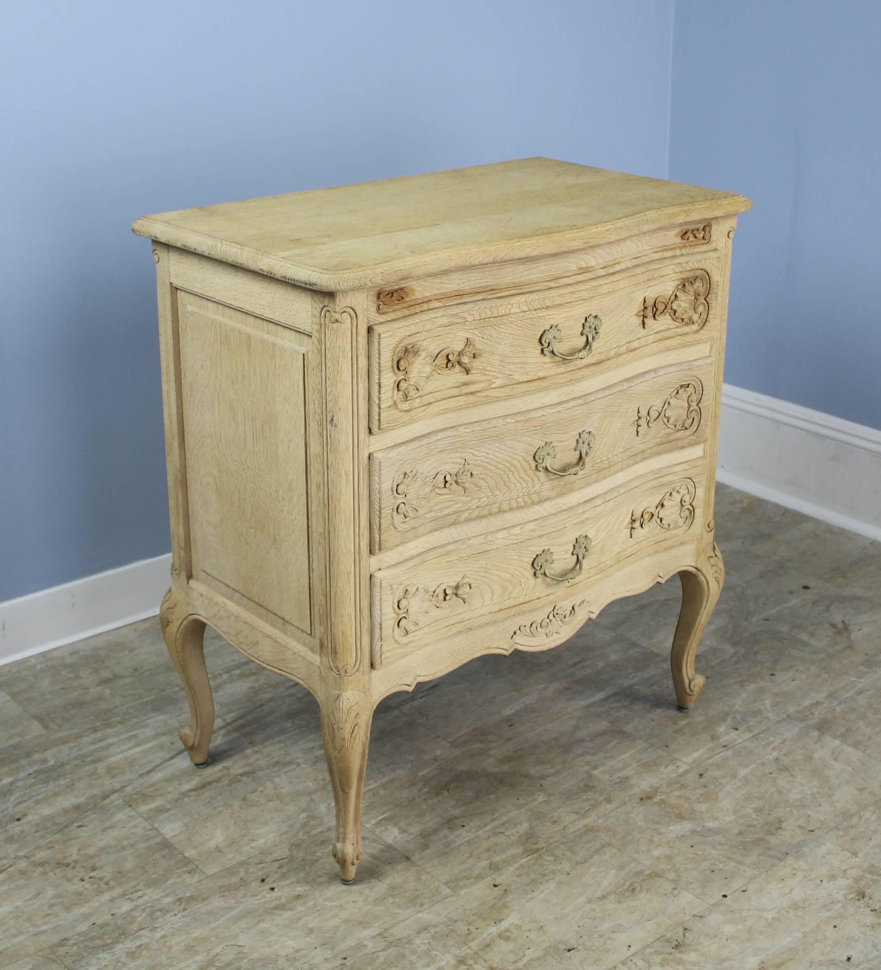 A fancifully carved three-drawer oak chest of drawers, bleached for a clean, modern look. Perfect for the bedroom or country sitting room. Unique!