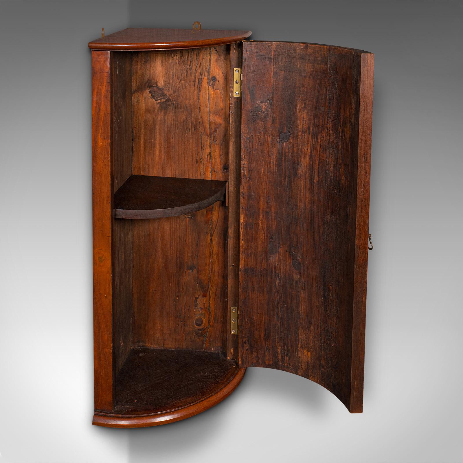 This is a delightful Georgian period wall cabinet, offering compact storage with elegant form, dating to circa 1800. This small antique corner cupboard is ideal for the kitchen, bathroom, or dining room.

Charming Georgian corner cabinet, with a