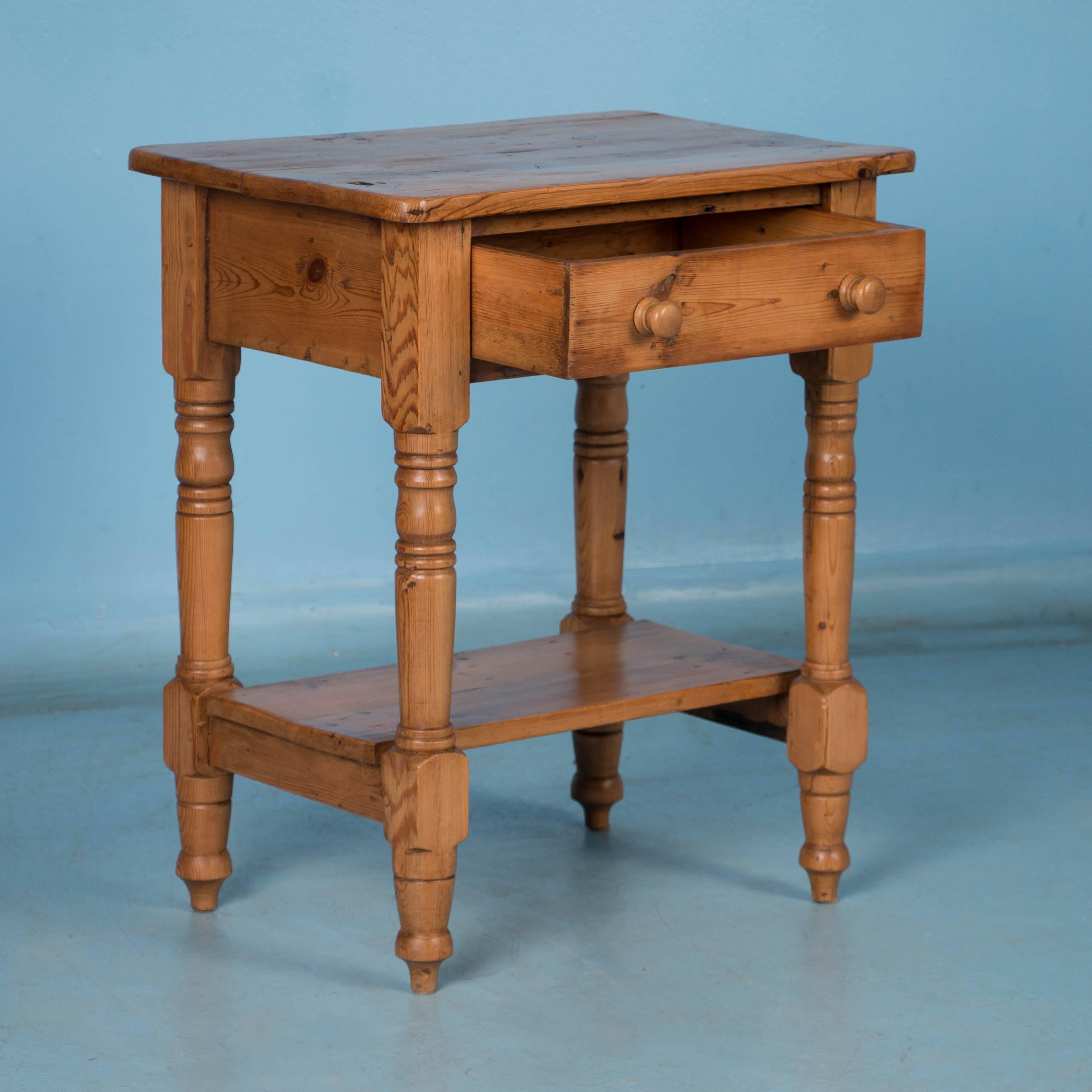 This charming antique pine side table features a single drawer, lower shelf and turned legs with a real country feel. The small size makes this ideal for use as an nightstand or end table. The table has been professionally restored and sealed with a