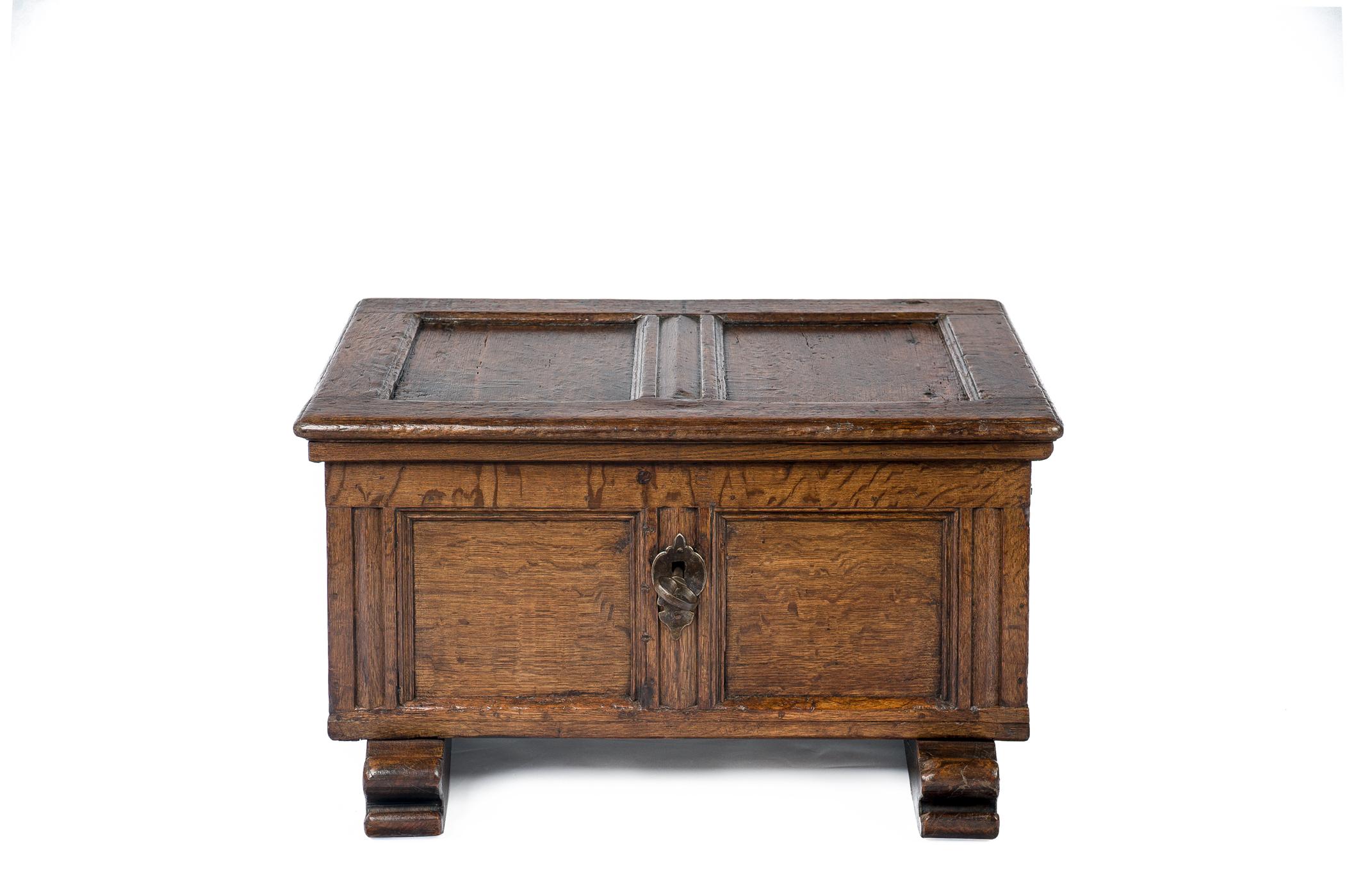 This small table trunk was made in Germany in the early 18th century. Both front and lid have two flat recessed panels with molded trim. It has the original forged steel keyplate, lock, and hinges. On the interior, there is a small candle box. The