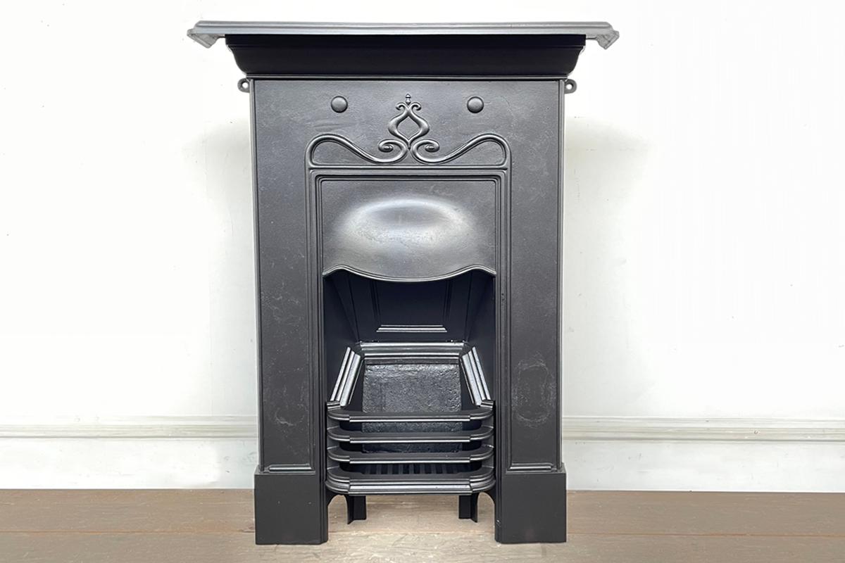 A small pretty Edwardian Art Nouveau cast iron bedroom fireplace. Circa 1905.

This fireplace has been fully restored and finished in heat resisting black paint.

For detailed sizes please see the size diagram in the image gallery.
 