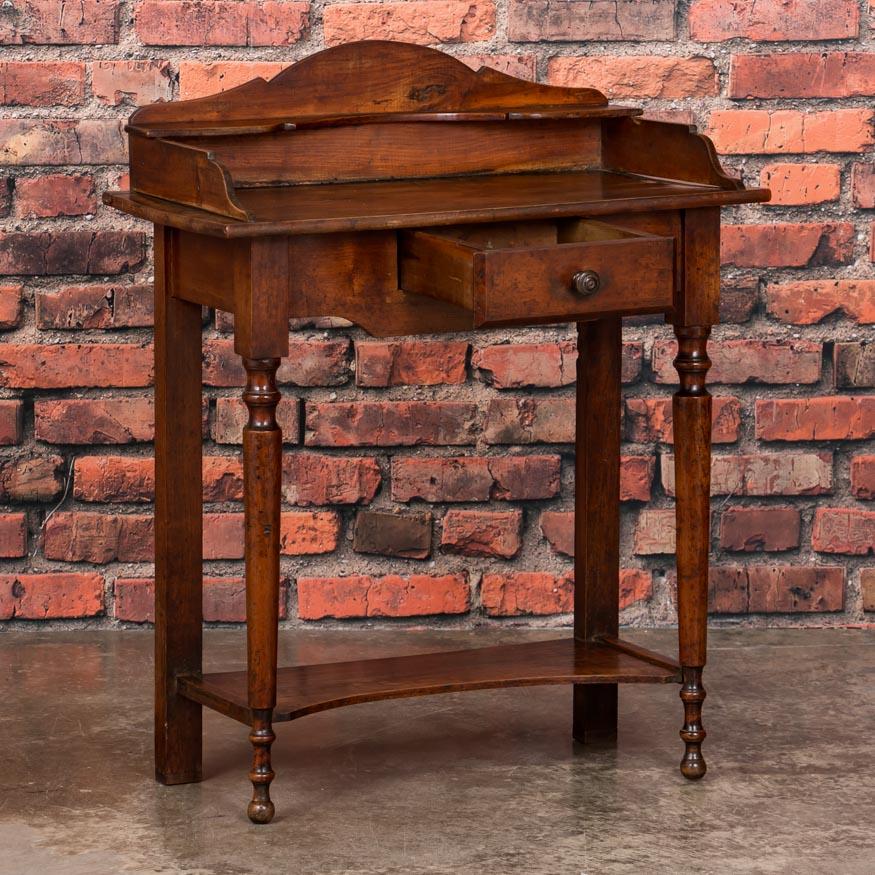 This country side table with it's time worn red patina has great architectural lines that add to the visual impact with an arched gallery, diminutive drawer and turned legs. Due to the small size of this pine side table, it may be used in a variety