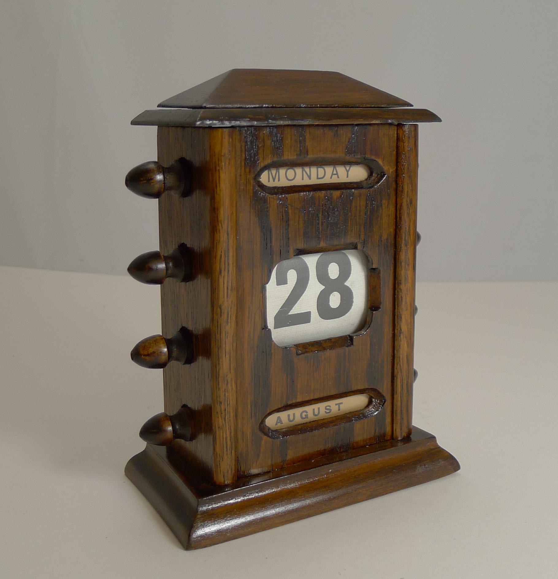 A most handsome English perpetual calendar made from solid English oak and dating to circa 1900, late Victorian or Edwardian in era.

The four knobs to each side are used to move forward and rewind the day, date and month behind the three glazed