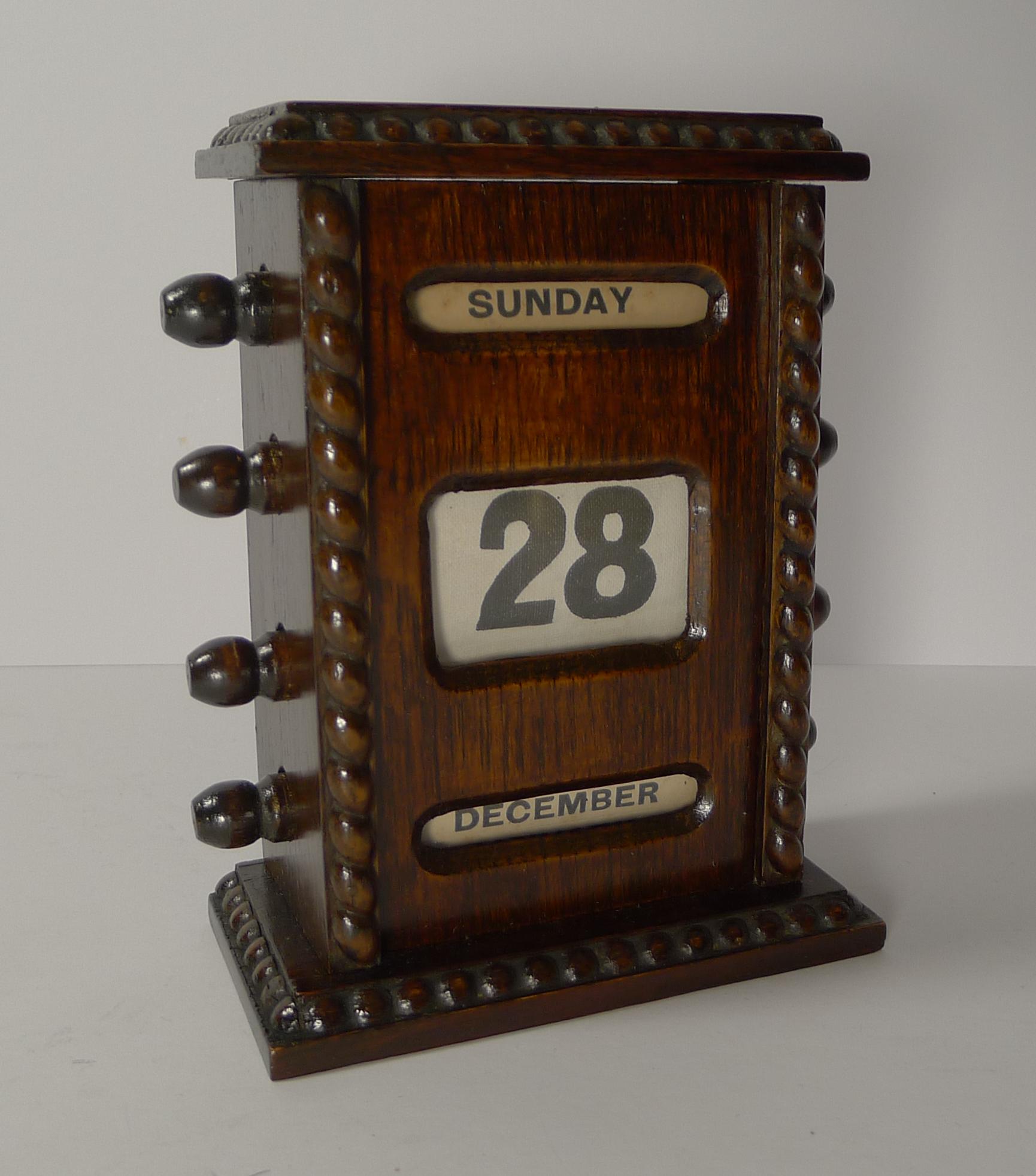 A handsome desk-top wooden perpetual calendar made from solid English oak with some nice carved detail.

The keys to the sides are used to forward and return the day, date and month rolls behind the glazed apertures.

Dating to the Edwardian