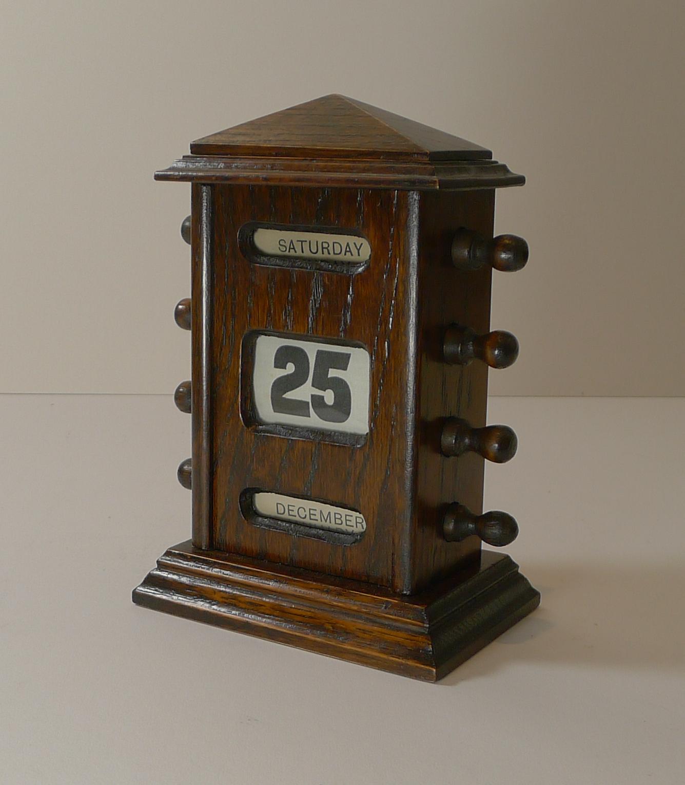 A handsome desk-top wooden perpetual calendar made from solid English.

The metal keys to the sides are used to forward and return the day, date and month rolls behind the glazed apertures.

Dating to the Edwardian era, c.1900 it remains in