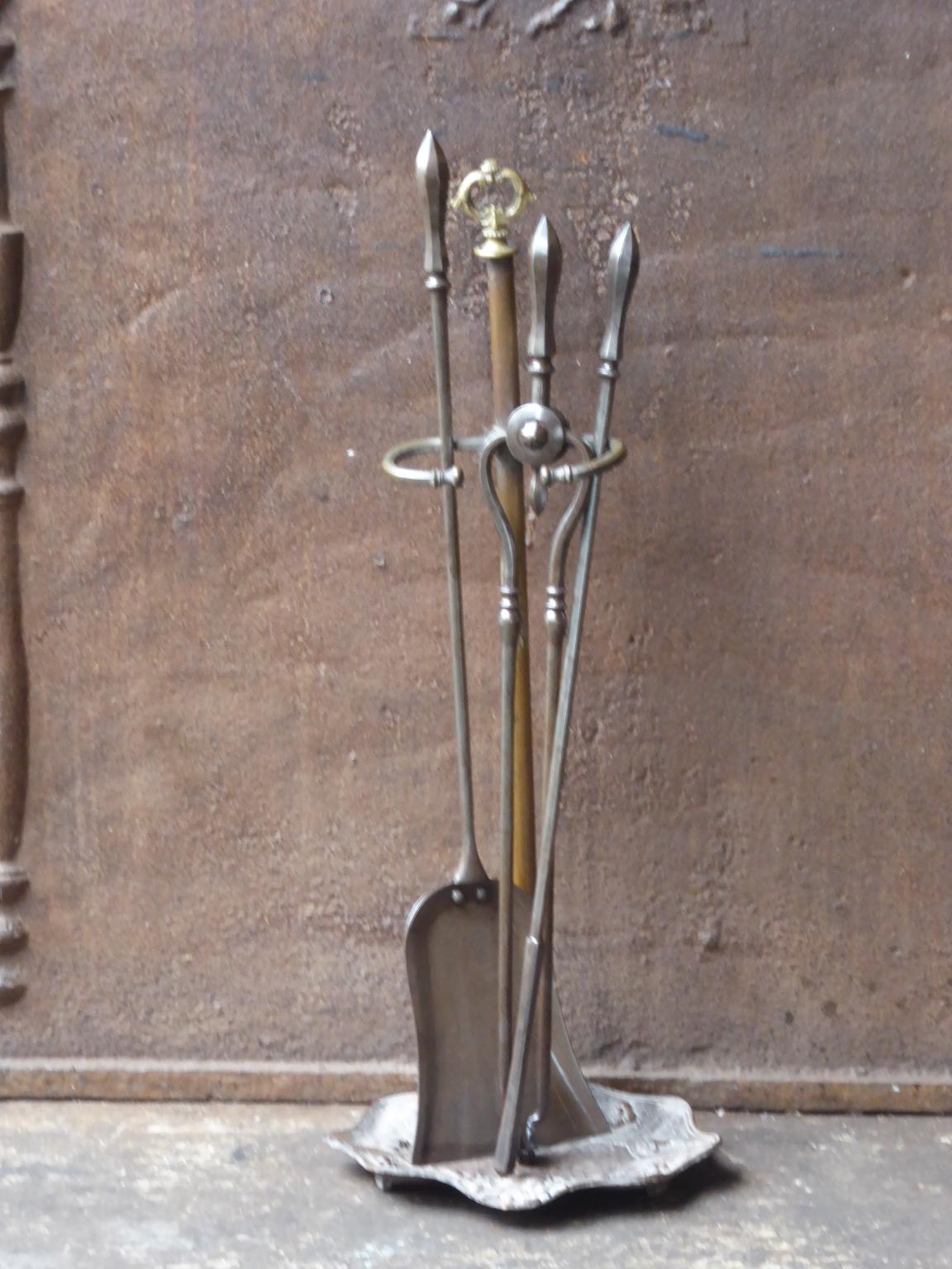 Small 19th century English Victorian fireplace toolset made of wrought iron and brass. The toolset consists of three fire irons and a stand. The condition is good.













 