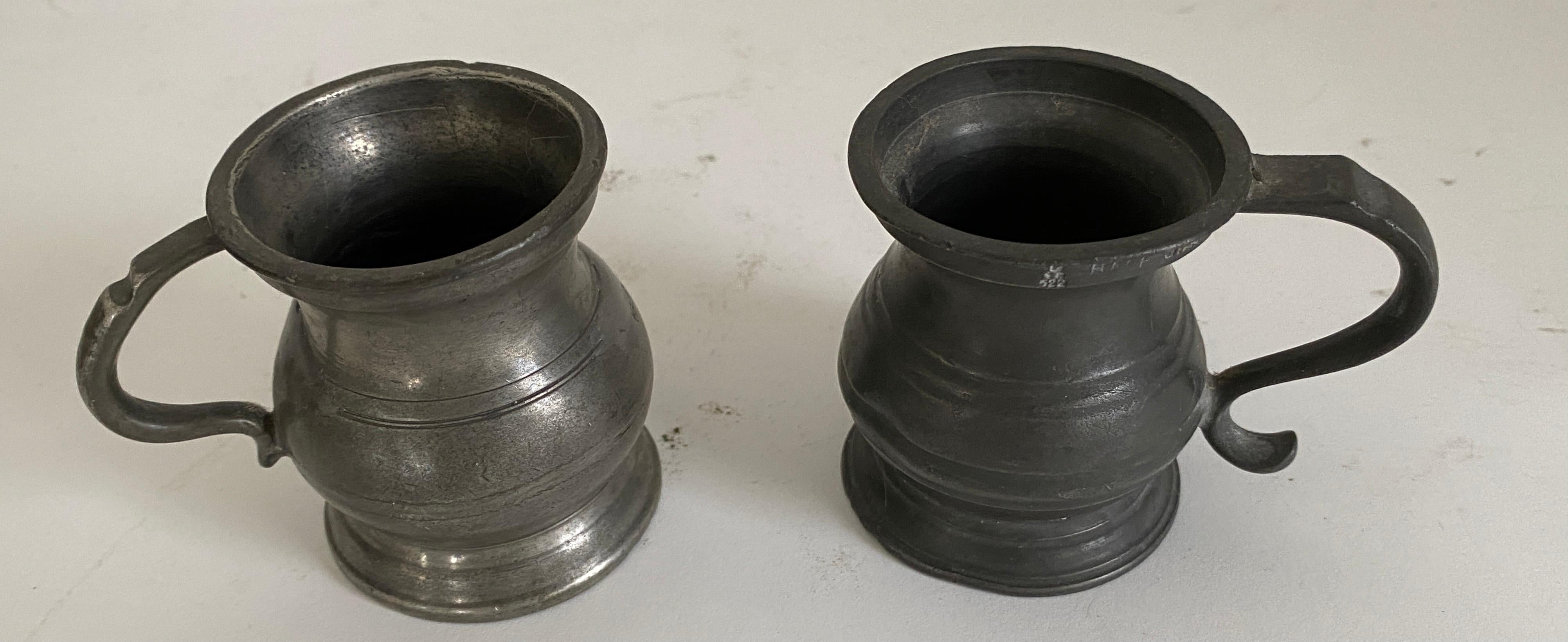 Not quite a matching pair of imperial measures made of pewter in the shape of one handled mug or tankard. These measures are generally graduating in size and each labelled accordingly with makers stamps to top rim, outside body, inside base or base.