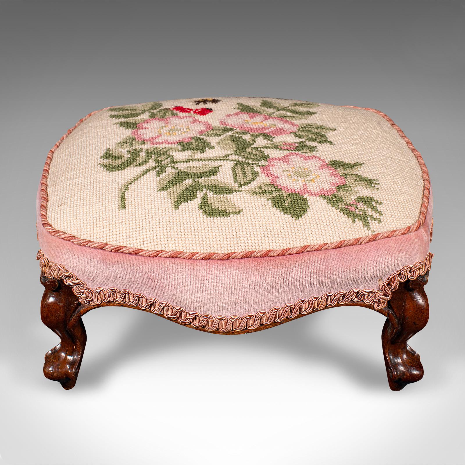 This is a small antique footstool. An English, walnut and embroidered textile low fireside footrest, dating to the early Victorian period, circa 1840.

Beautifully presented with a palette of attractive colours
Displaying a desirable aged patina and