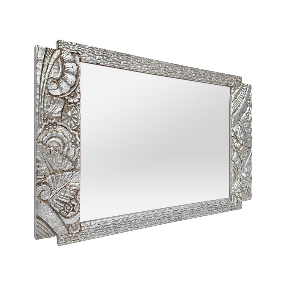 Small antique French Art Deco period wall mirror, circa 1925. Orned of stylized plants and flowers carved in low relief in Art Deco style. Antique frame re-silvered with leaf. Frame width: 2.5 & 6 cm / 0.98 & 2.36 in. Modern glass mirror. Wood back.