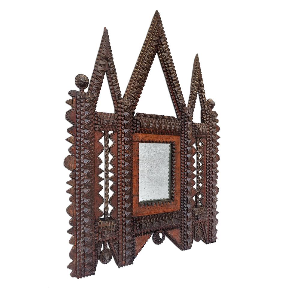 Small antique French carved wood mirror, Tramp Art style, circa 1910. Hand-made of painstakingly assembled small pieces of diamond-shaped cut wood the mirror frame consists of three triangular pediments and pyramid-shaped elements. Antique mercury