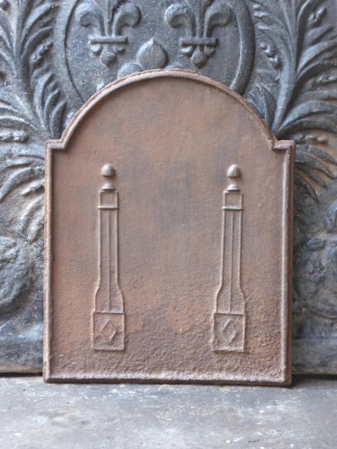 Small 19th century French neoclassical fireback with two pillars of freedom. The pillars symbolize the value liberty, one of the three values of the French revolution. 

The fireback is made of cast iron and has a natural brown patina. Upon