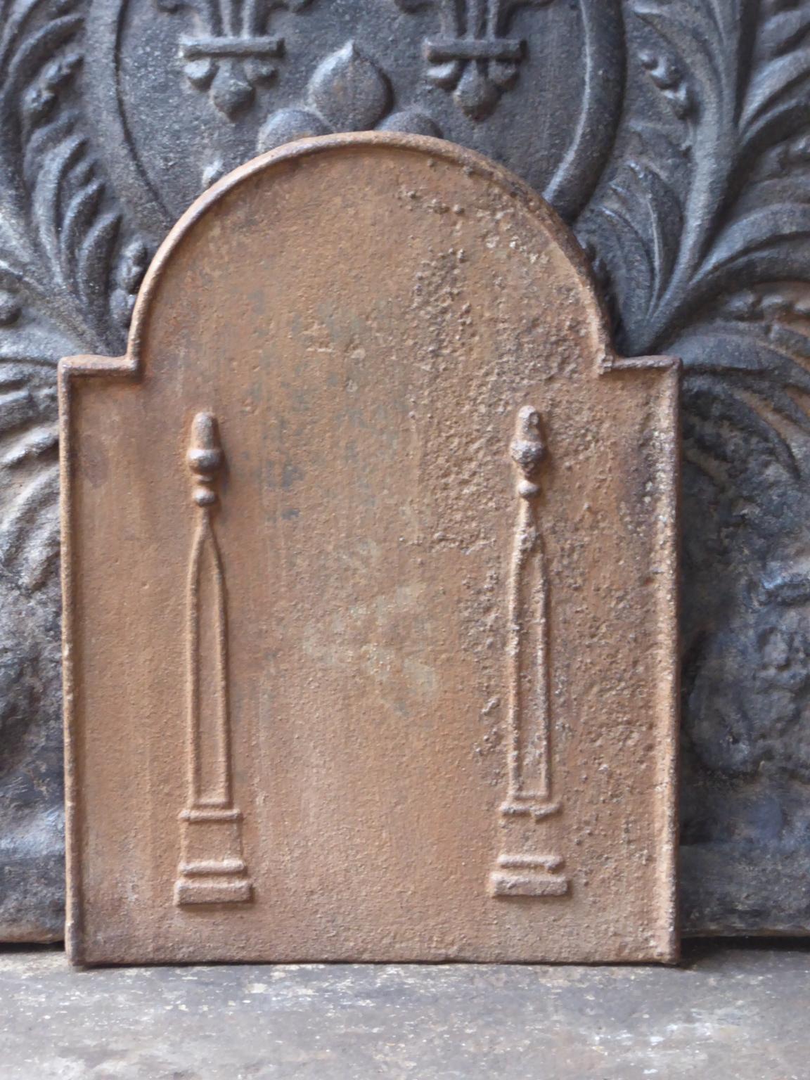 Small 19th century French neoclassical fireback with two pillars of freedom. The pillars symbolize the value liberty, one of the three values of the French revolution. 

The fireback is made of cast iron and has a natural brown patina. Upon request
