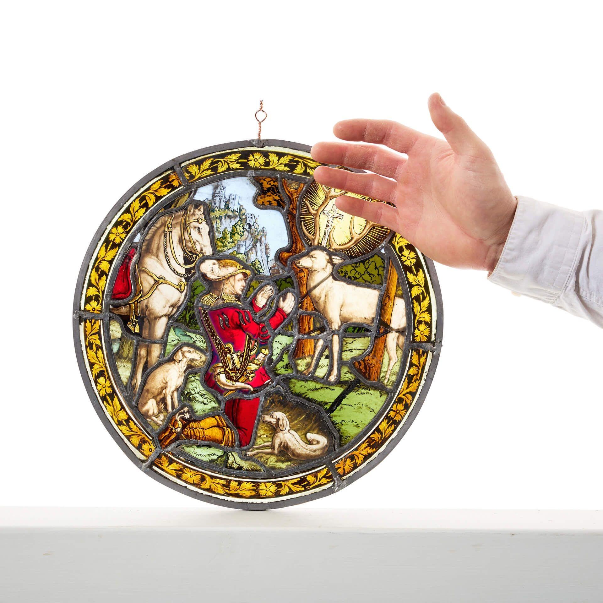 Ein kleines antikes deutsches Buntglas-Rondell mit der Darstellung des Heiligen Hubertus und des Hirsches.

Der heilige Hubertus ist der Schutzpatron der Jäger, der dafür bekannt ist, dass er auf der Jagd nach einer Begegnung mit einem Hirsch eine