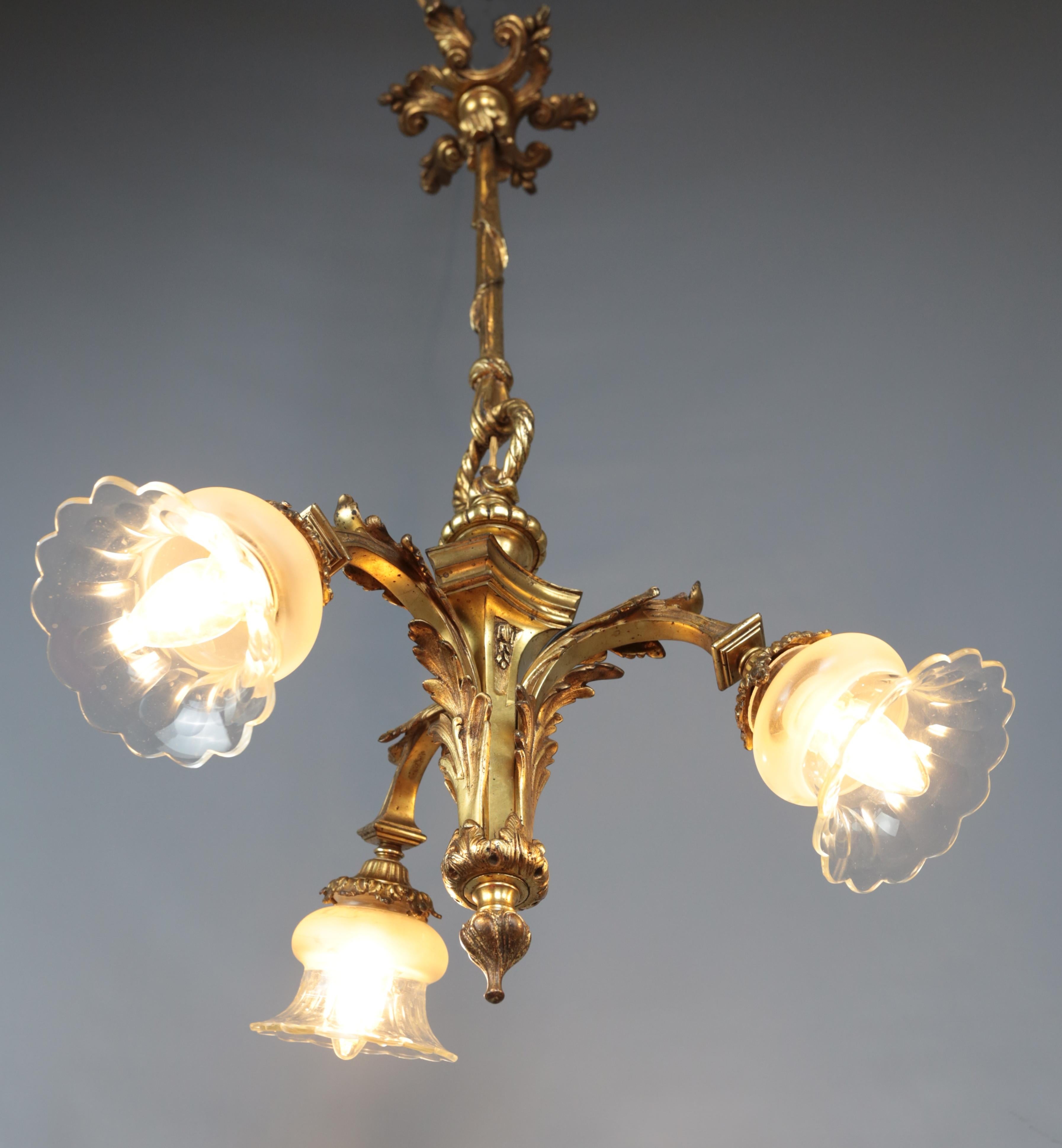 Small antique gilt bronze chandelier

A small chandelier of the Mazarin type in gilded bronze. The chandelier is very well cast. Shades are glass, partially etched glass. The chandelier is for three bulbs with a classic E27 thread up to 40W (normal,