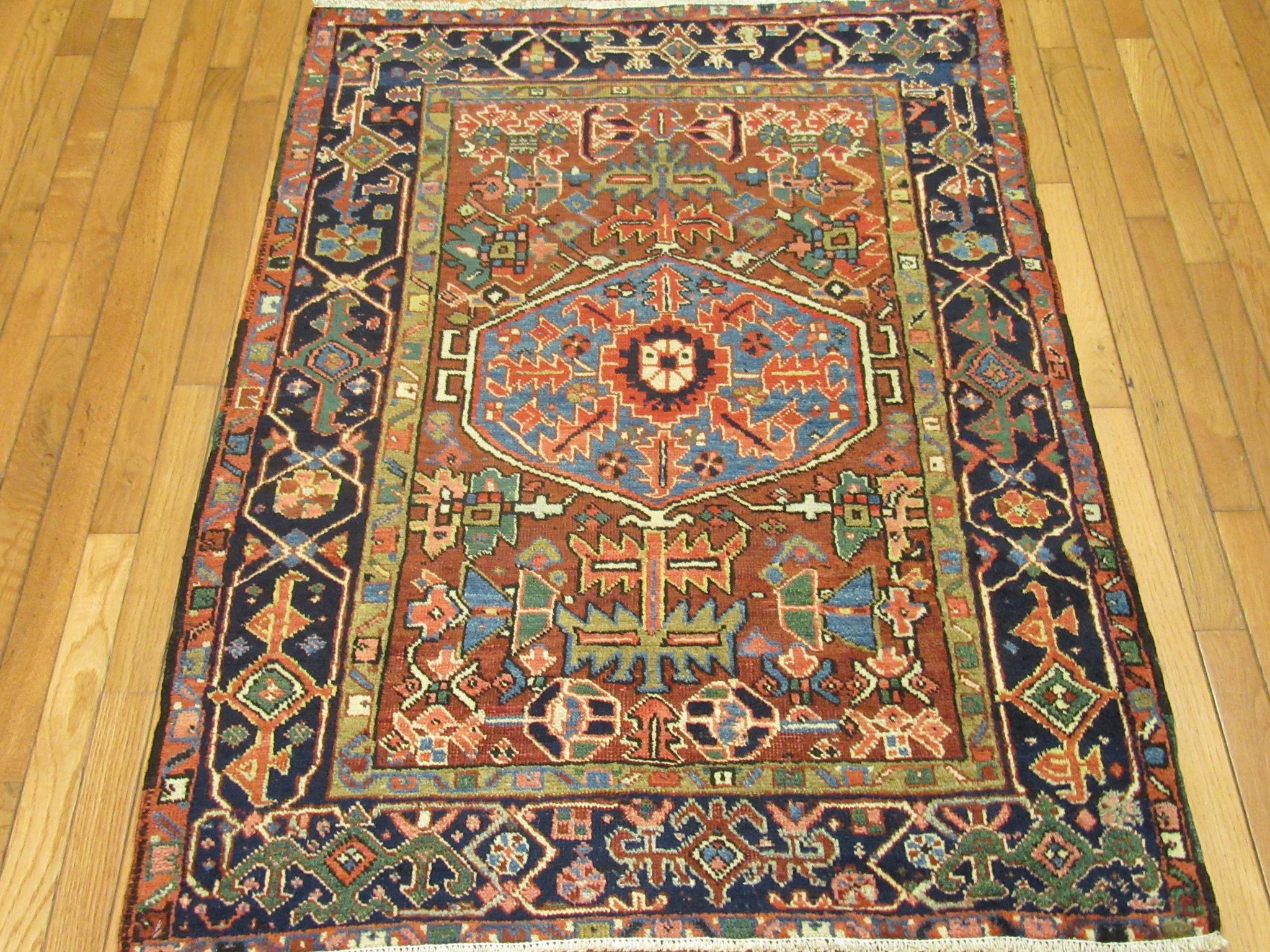 This a small antique hand-knotted Persian rug in the Heriz style design. It is made with wool colored with natural dyes on a cotton foundation. The rug measures 3' 5'' x 4' 5'' an easy size for placement in any room at home or office.