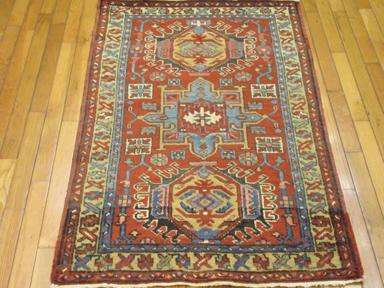 This is a small antique hand-knotted Persian Heriz rug made with wool colored with natural dyes on a cotton foundation. It has the multiple medallion common in Karajeh rugs. It measures 2' 8'' x 4' 5'' and in great condition. A perfect rug for any