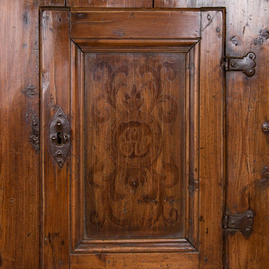 The rich patina of the antique pine is evidence of it's age in this very early hanging cabinet with original hand forged hardware and hand cut molding. Adding to the charm, are remnants of the original folk art paint that can still be seen outlined