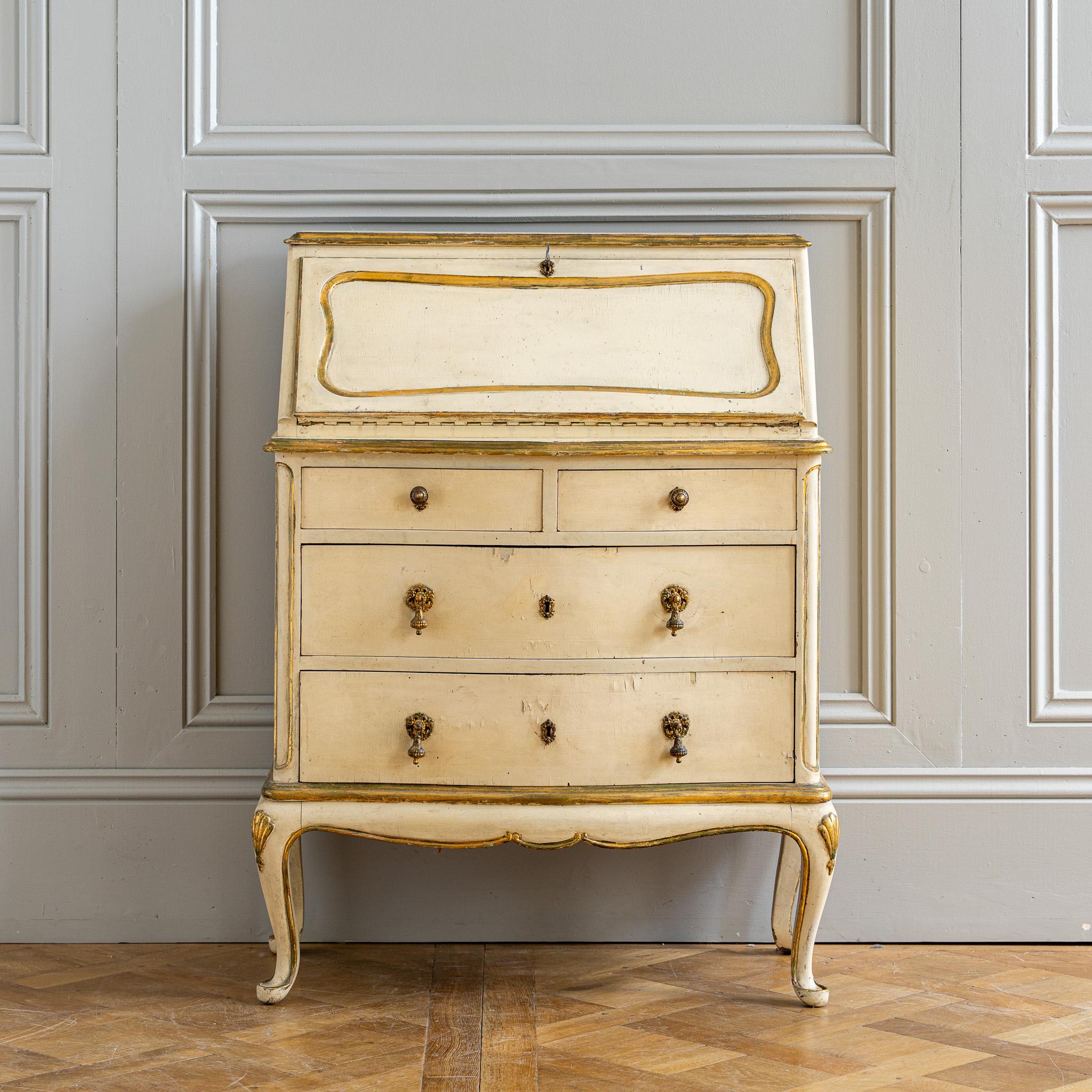 Circa late 19th century, this small Italian Scriban carries the gentle character of age with its original painted finish and beautifully balanced proportions. The exterior is rendered in a naturally aged warm antique white, with gilded highlights