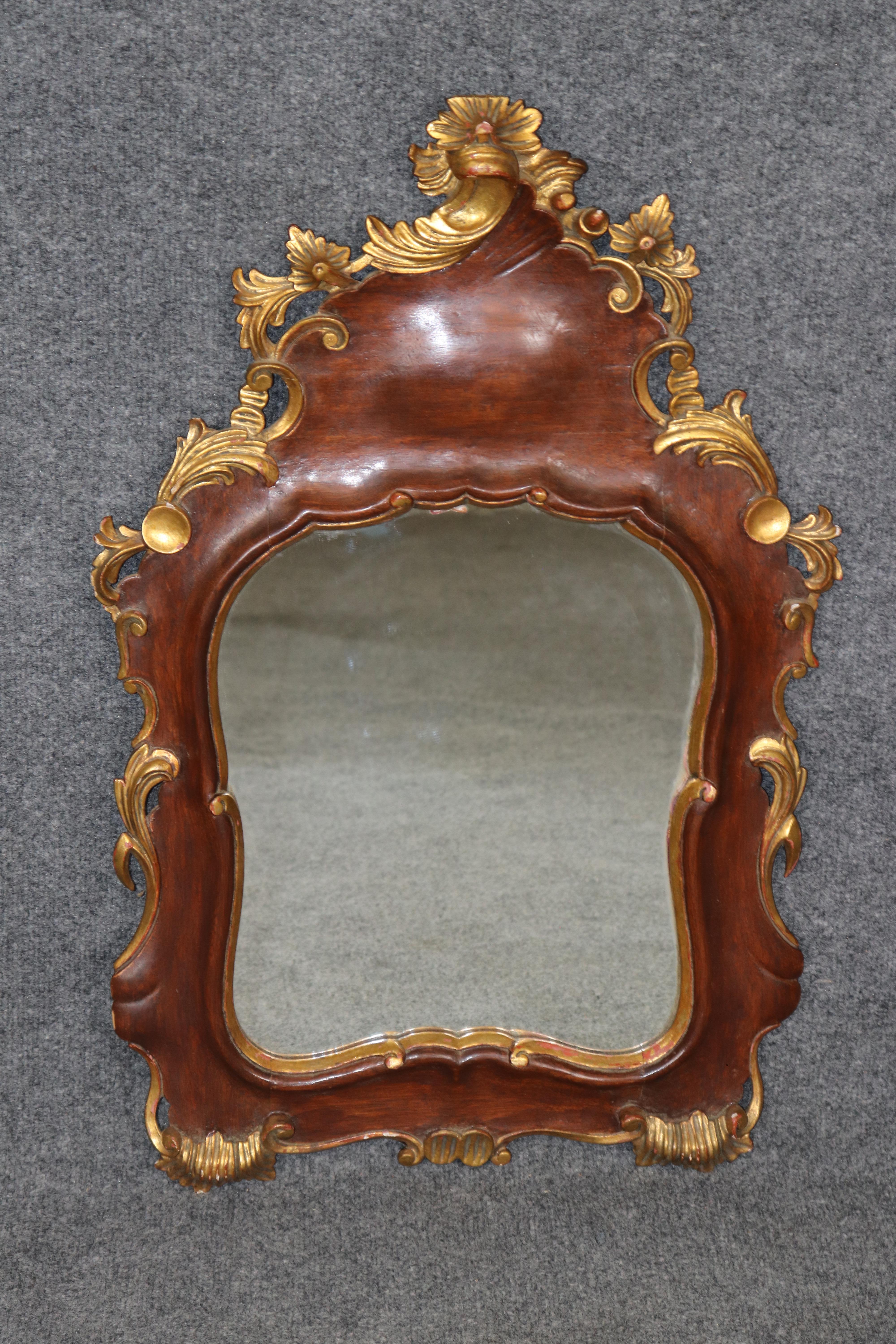 Dimensions - H : 29 1/2 in W : 19 1/2 in D : 2 1/2 in 

Cet exquis miroir mural italien de style rococo du début du XXe siècle est un exemple raffiné de l'artisanat d'antan dans une forme charmante et compacte. Elegamment sculptée et finie en riche