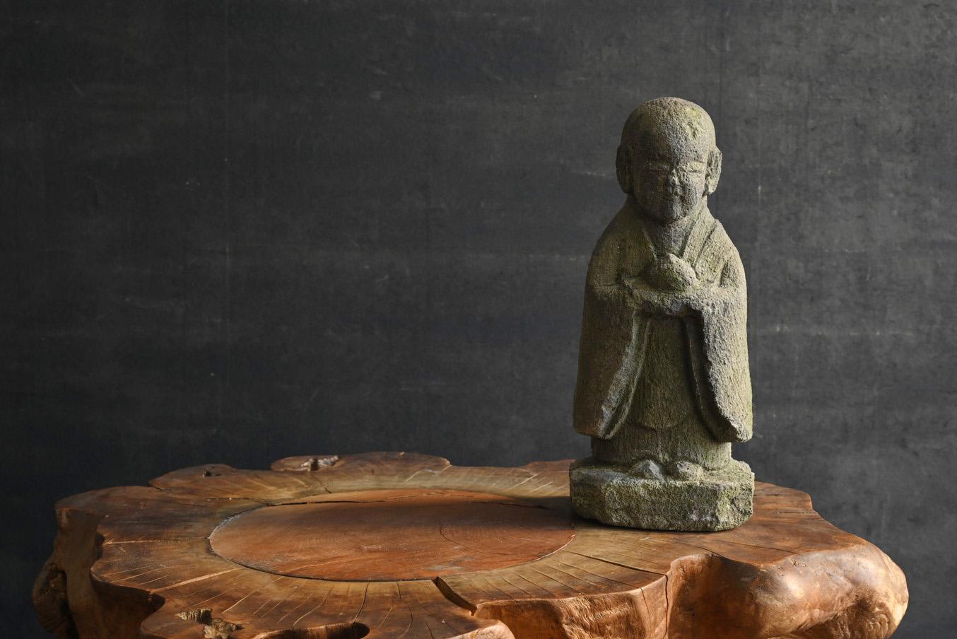 This is a small Japanese stone Buddha.
It is thought to have been made around the Edo period.
It is thought to be a Buddhist statue called Jizo Bodhisattva.
Although it is small, this item is well carved.

The face, kimono sleeves, etc. are carved