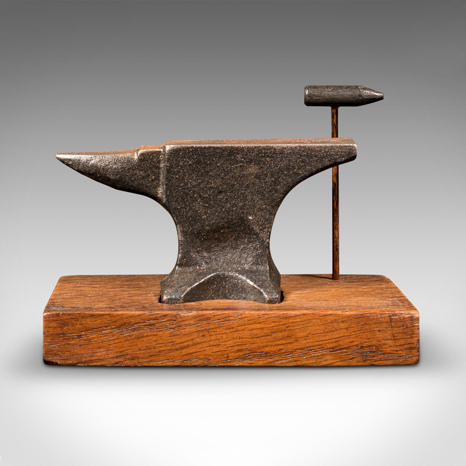 This is a small antique jeweller's anvil. An English, cast iron decorative tool set on an oak plinth, dating to the Edwardian period, circa 1910.

Delightfully petite, with appealing sings of use
Displays a desirable aged patina and in good