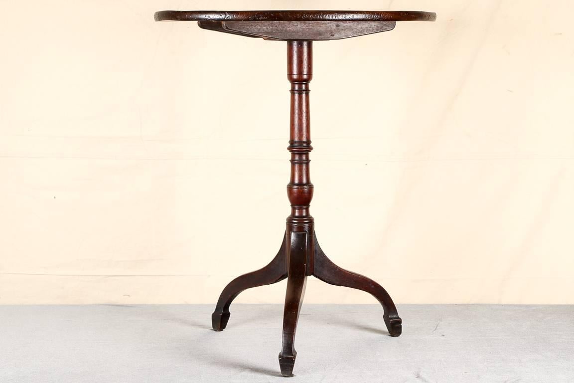 Antique tilt top table, mahogany, oval top with a turned baluster form standard supported on a tripod base ending in spade feet.

Condition: expected wear and signs of use including some minor surface scratching and sporadic nicking along corners