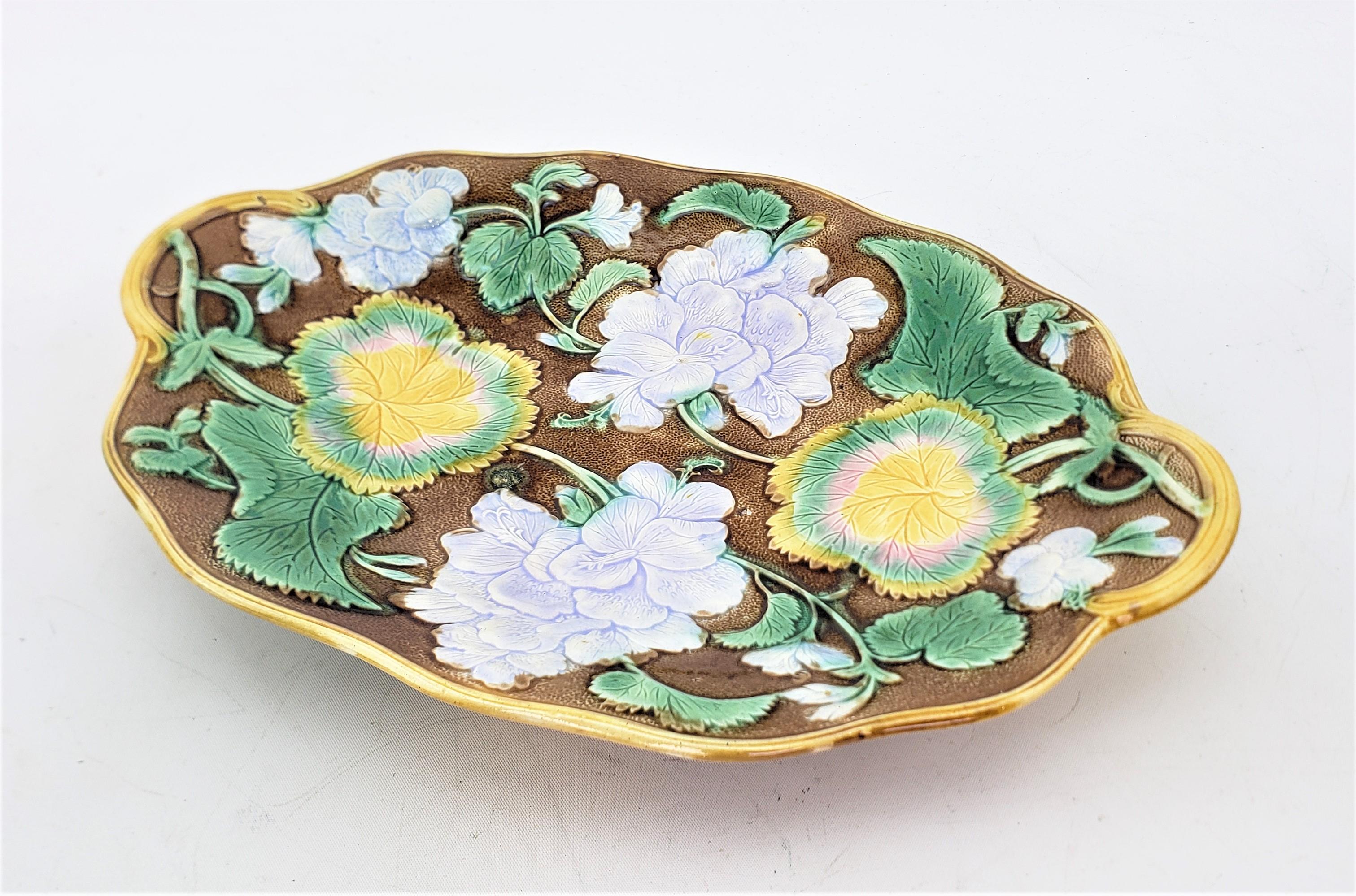 This small antique platter or server is unsigned, but presumed to have originated from England and date to approximately 1880 and done in the period Victorian style. The server is composed of majolica and is done in a variety of green, brown, gold,