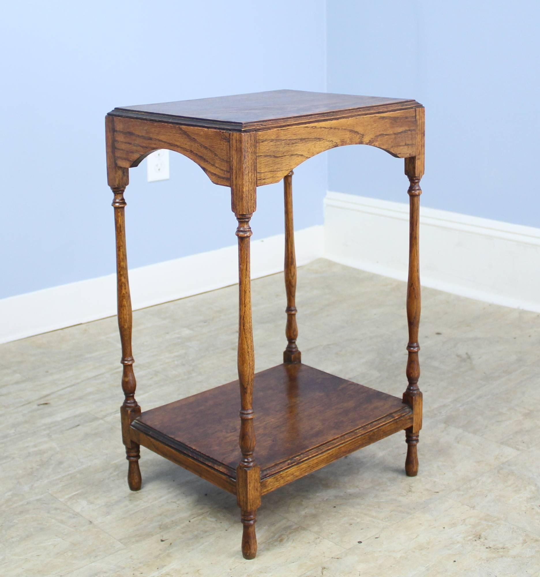 A charming oak side, lamp, or occasional table, with a lovely grained top and delicate turned legs. This piece is in very good antique condition.