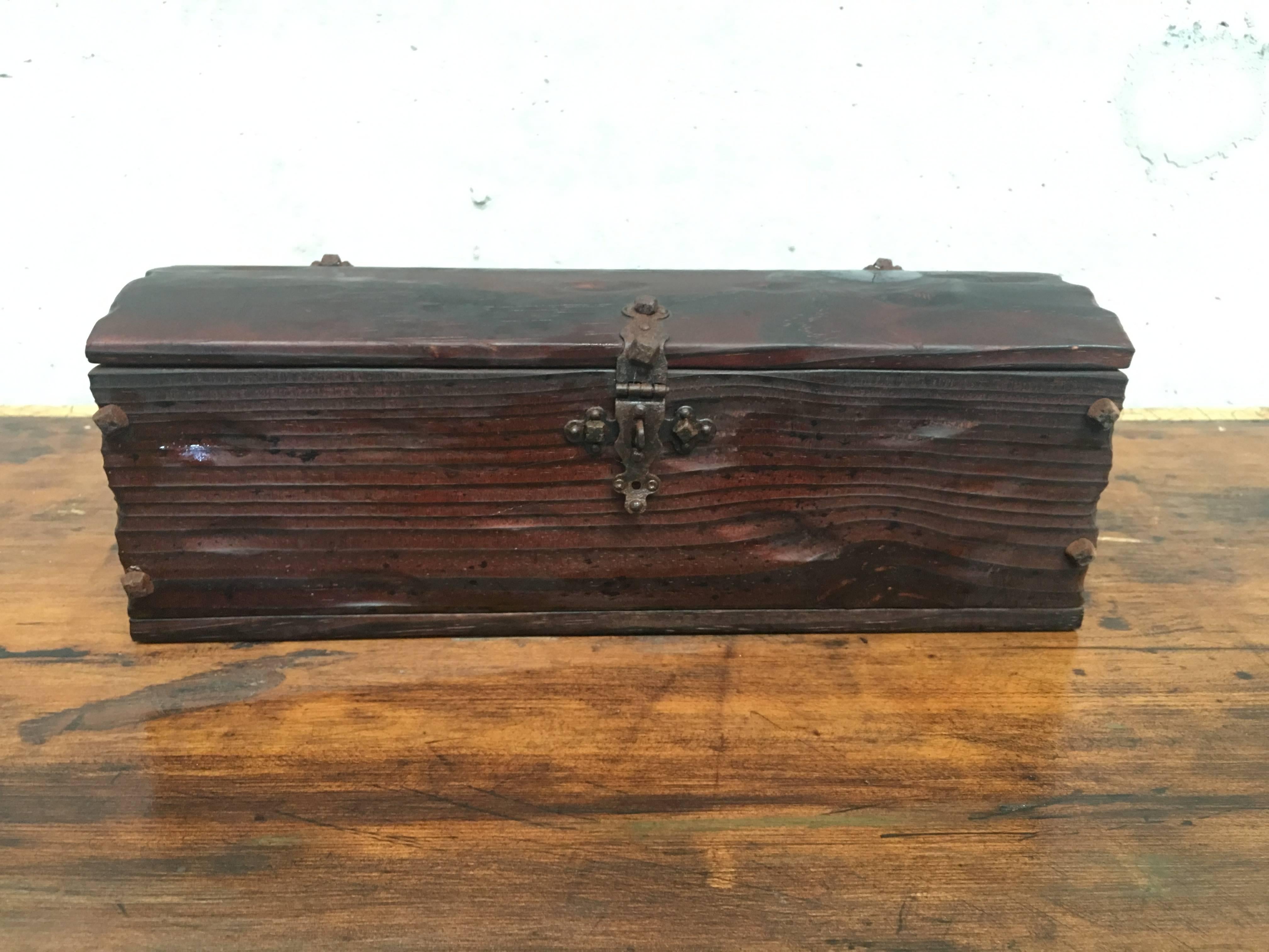 This antique oak table trunk is from Spain and dates to the 1700s. The top is attached to the back panel with two wrought iron hinges with decorative straps. It is interesting to note that there are slightly different variations of similar carvings
