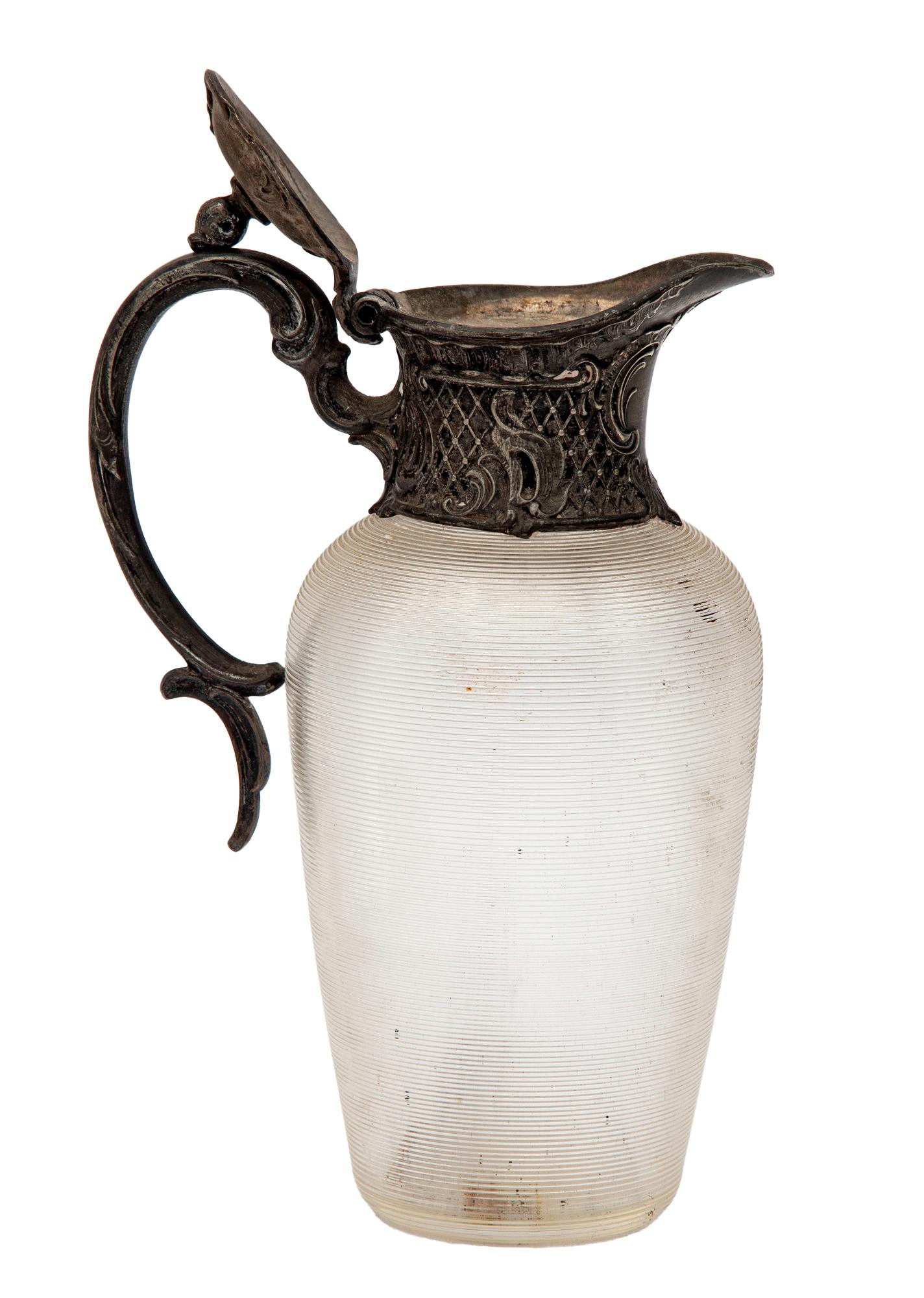 Art Noveau 19th century jug for oil, syrup or display.
The metal work has a French flair.
The crystal is hand etched with a ribbed design.