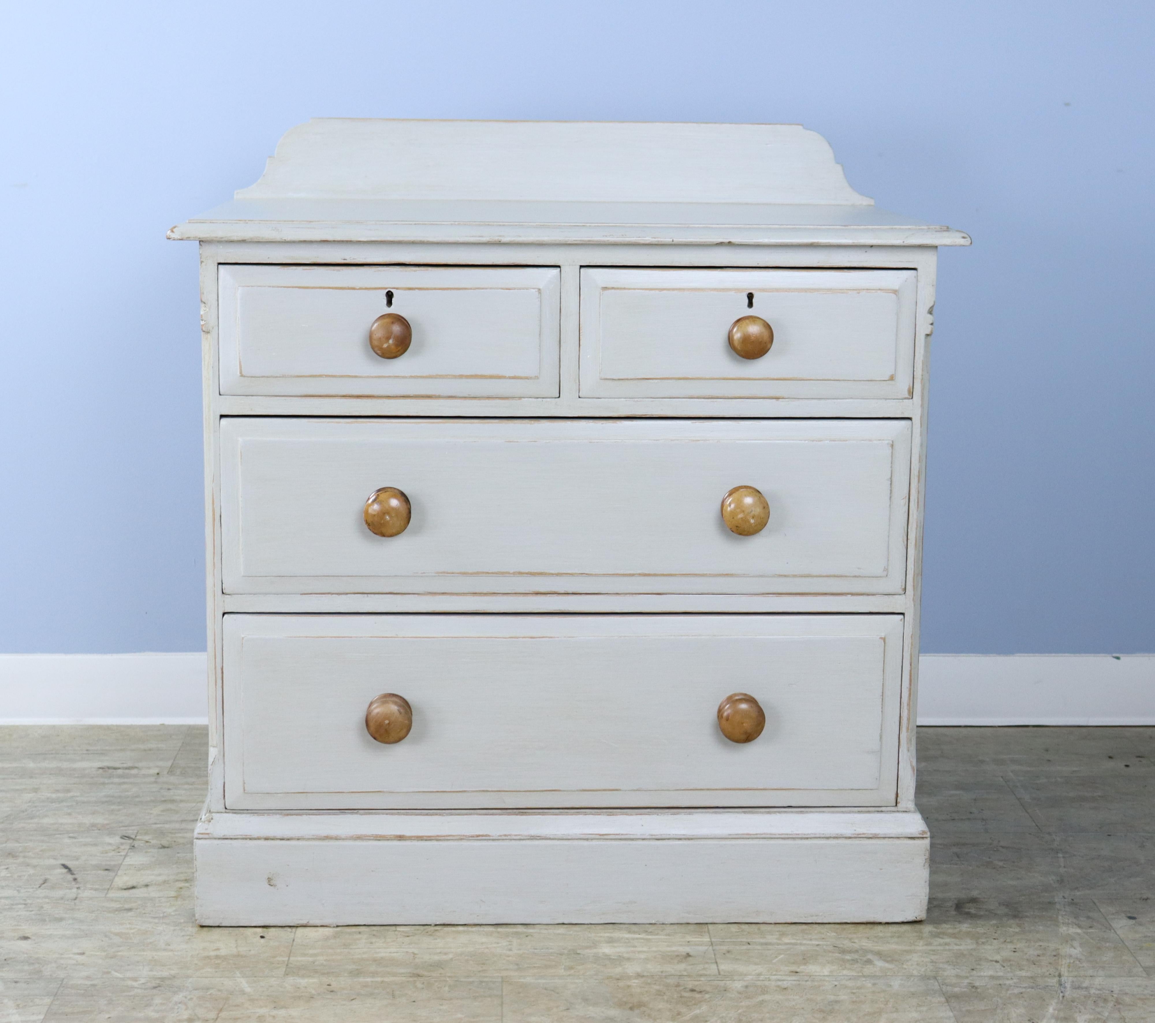 A small, charming chest of drawers with attractive knobs and refreshed gray paint. The height measurement below is for the height without the galleried back. The total height of the piece is 35 inches. The back of the piece is worn but sturdy.