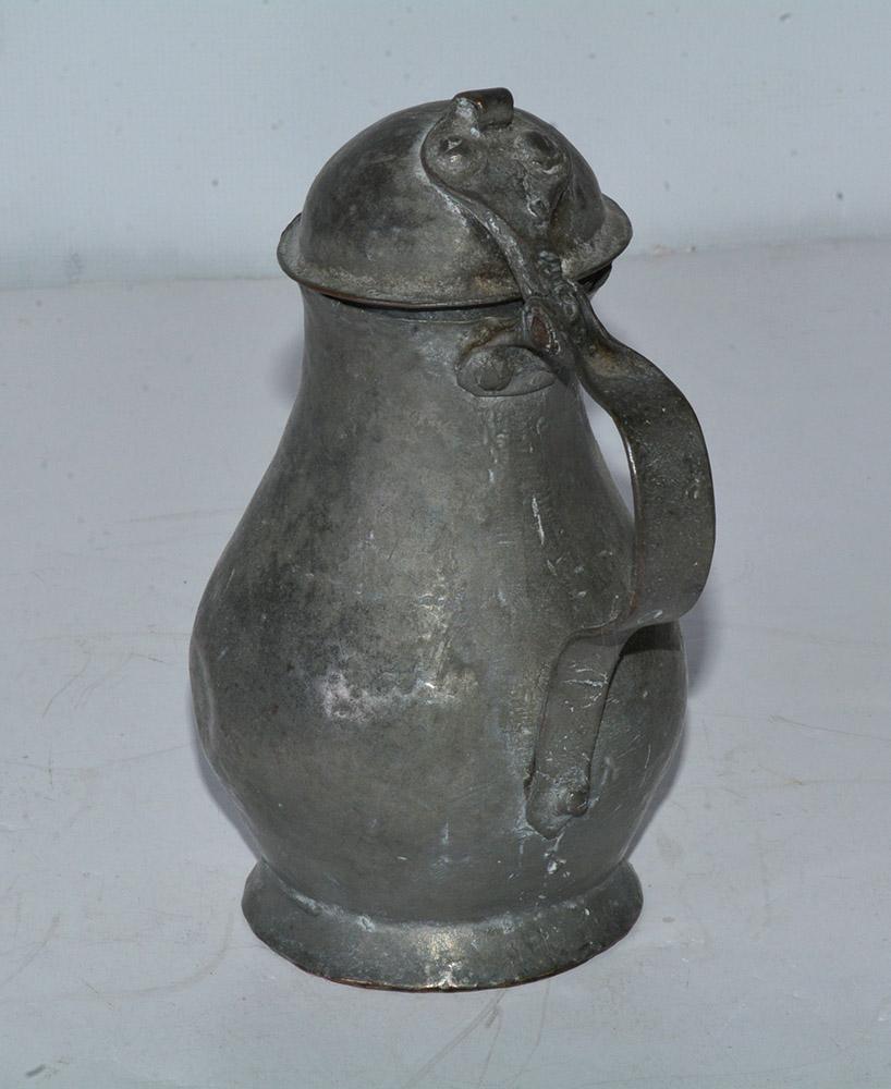 The small antique cream coffee pot or jug with lid is made of handcrafted hammered pewter. Makes a wonderful decorative object, not for use.