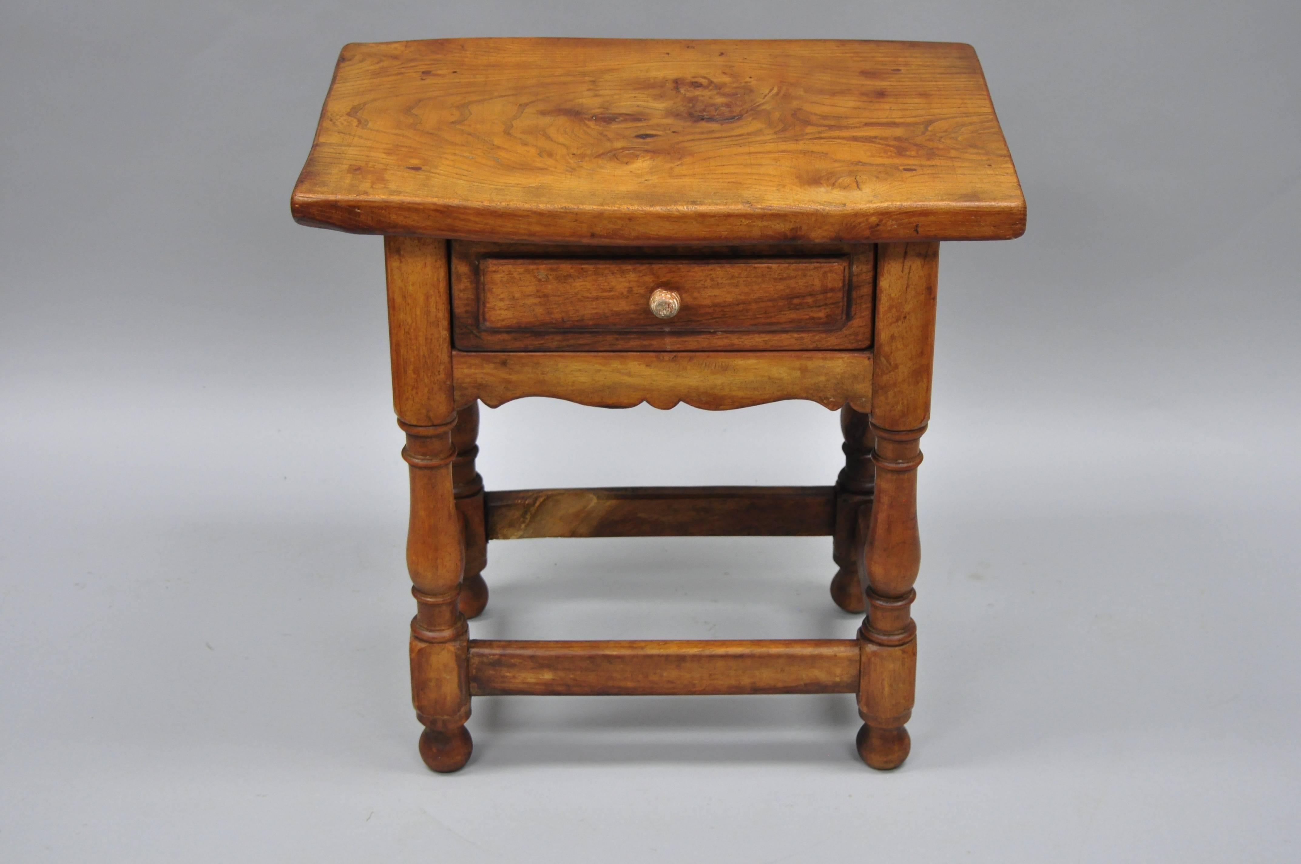 Small antique pine wood one drawer side table. Item features turn carved legs, stretcher base, beehive carved drawer pull, wonderful aged patina, solid wood construction, beautiful wood grain, one dovetailed drawer, and quality craftsmanship, circa