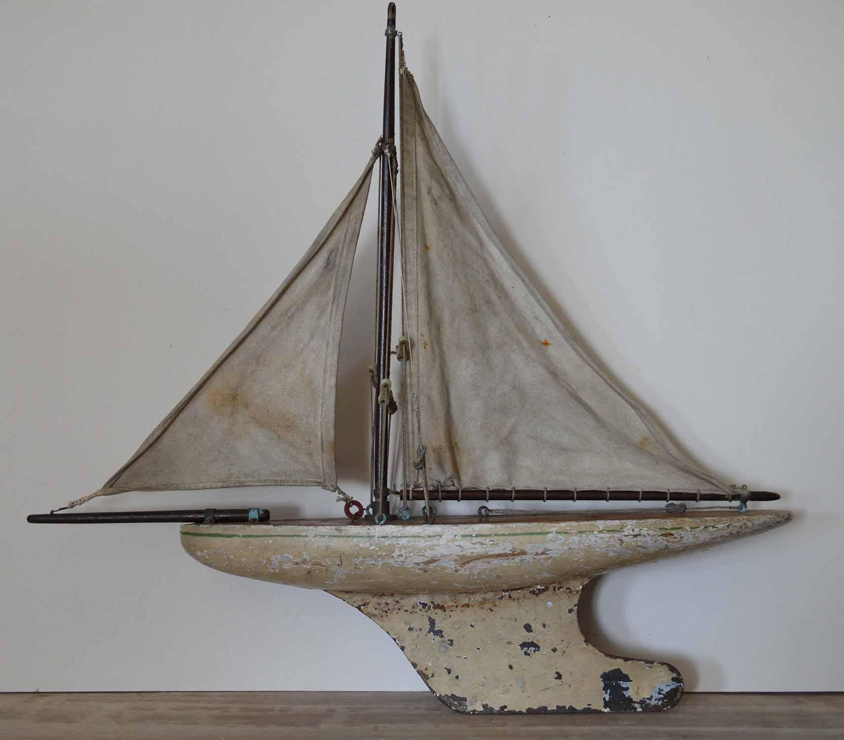Charming little free standing pond yacht.

Painted cream with a single green line detail.

Original paint and original canvas sails.

    