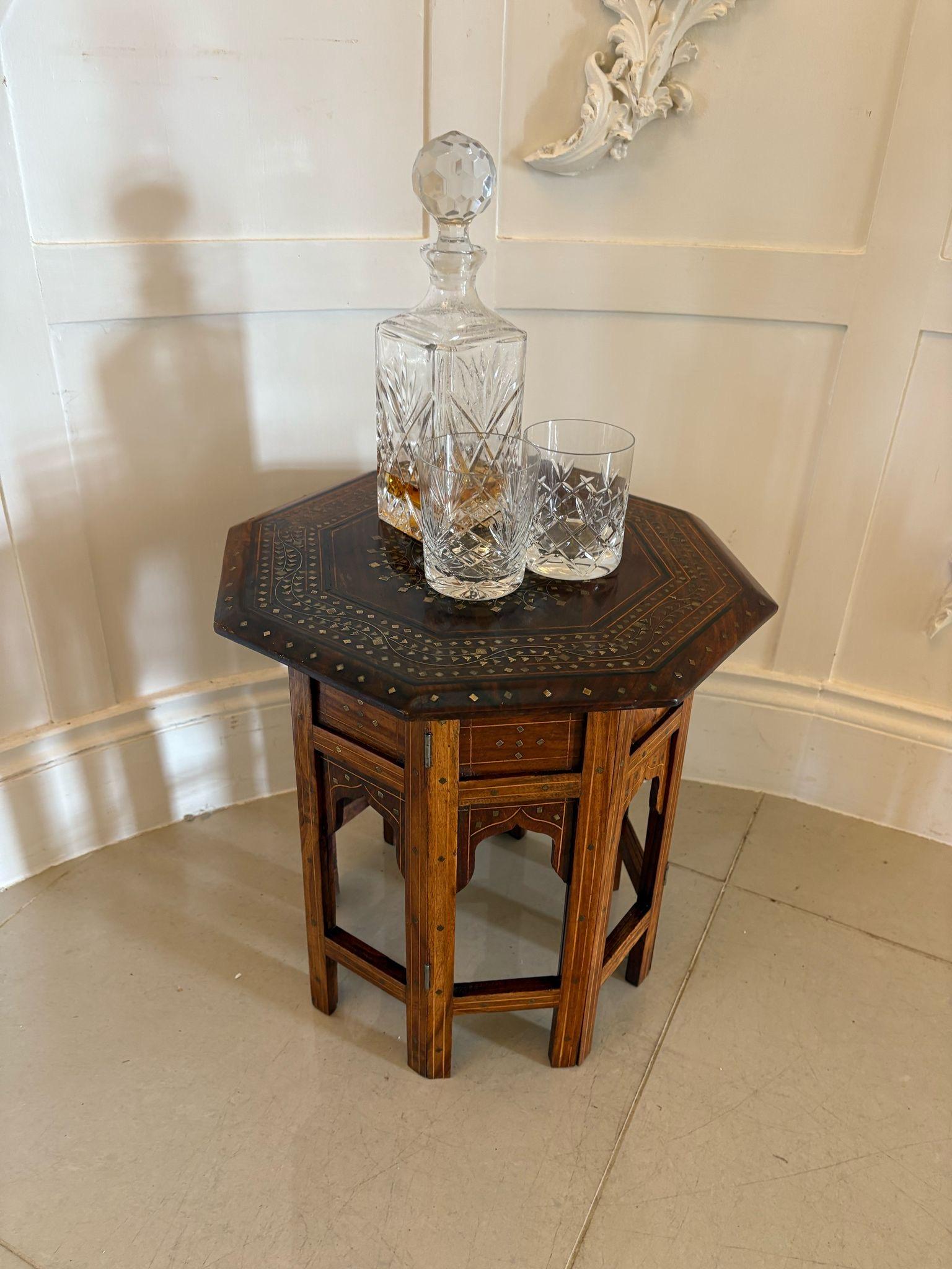 mall antique quality brass and bone inlaid Indian teak table having a quality brass and bone inlaid hexagonal shape top supported by a six section folding base with carved open panels.

A quaint example in lovely original