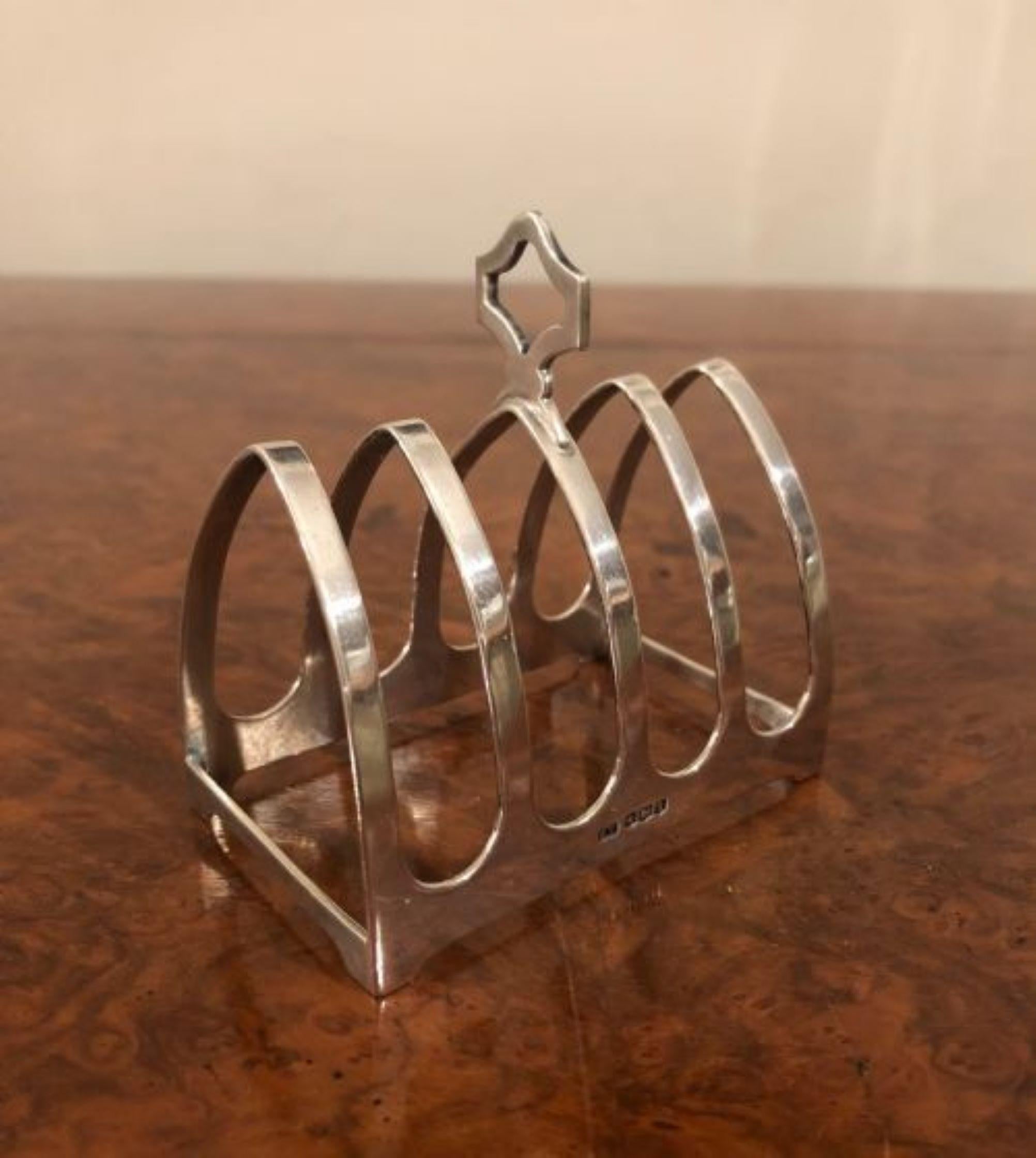 Small antique quality solid silver toast rack having a shaped handle & four sections for toast. 