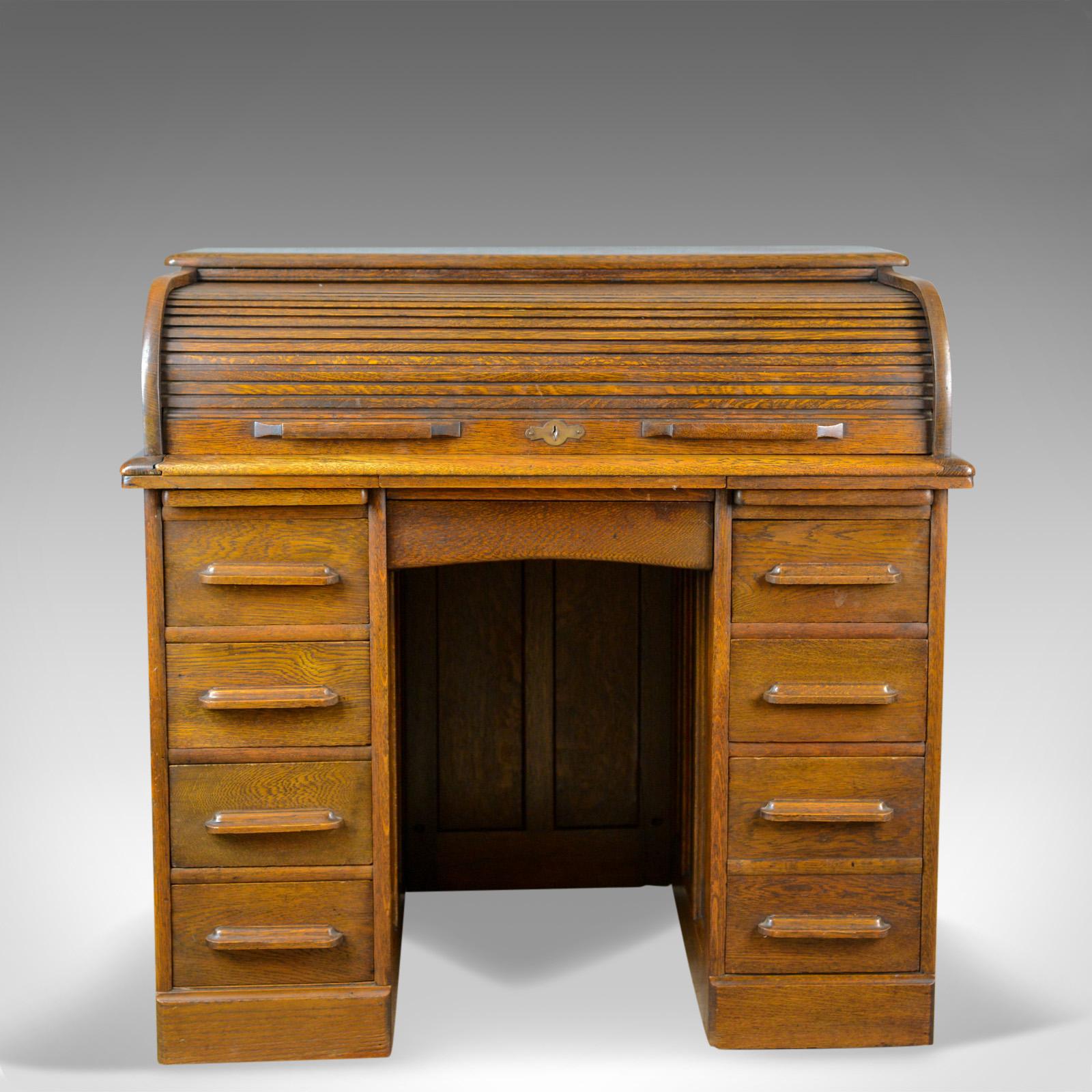 This is a small, antique roll-top desk in oak. Tambour top desk made by William Angus and Co Ltd, London in the Edwardian period of the early 20th century, circa 1910.

Super color and a desirable aged patina
Grain interest displaying wisps of