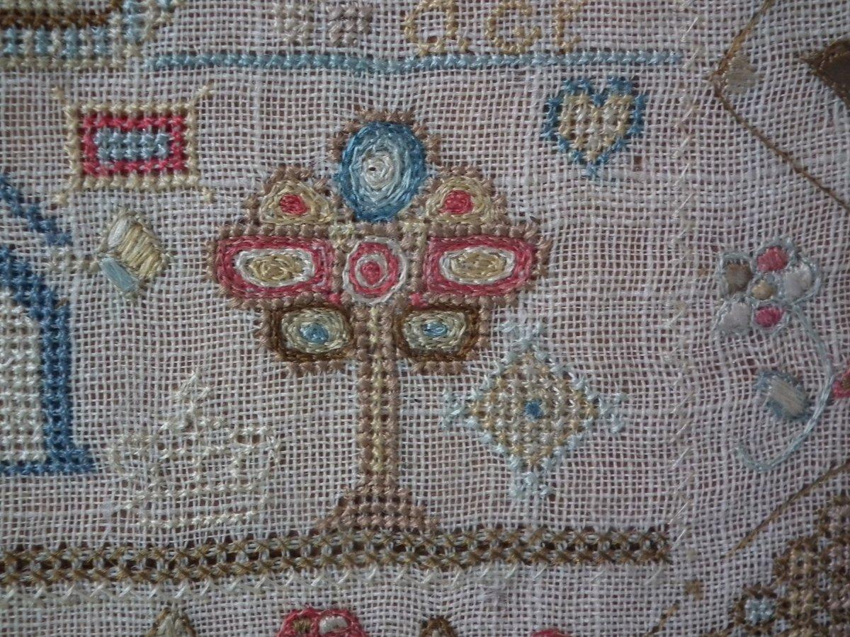 Small antique sampler, circa 1770, by Lydia Peakins. The sampler is worked in silk on linen ground, in a variety of stitches including Algerian eye. Zig zag and floral border. Colors pink, cream, red, pale blue, black, white and olive green.