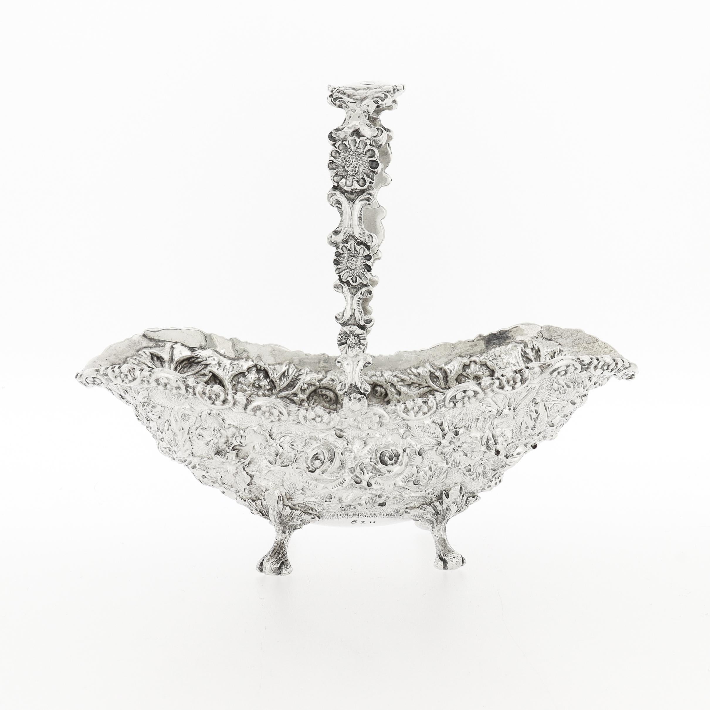 A fine, diminutive antique American sterling silver basket.

By The Schofield Company (1905 - 1977).

In sterling silver.

In a Baltimore Rose pattern reminiscent of Kirk's & Steiff's repousse patterns.

With a monogrammed cartouche to the curve of
