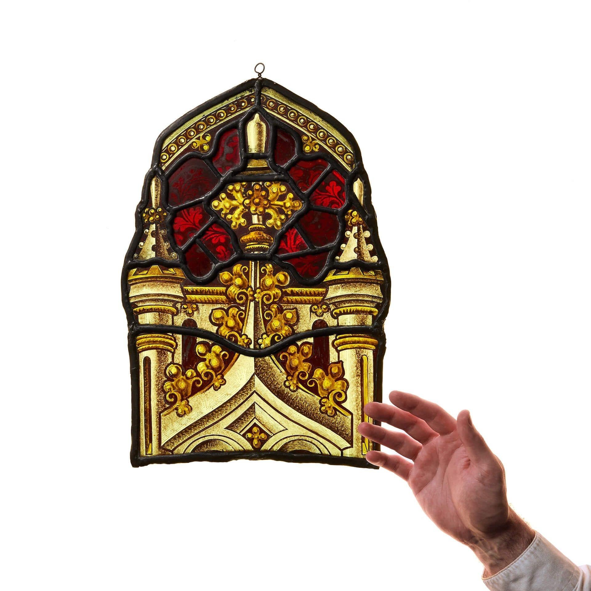 Un piccolo pannello in vetro colorato antico della fine del XIX secolo con gancio, pronto per essere appeso a una finestra o davanti a una fonte di luce dove i colori e i dettagli prenderanno vita.

Questa vetrata sospesa raffigura terminali e archi