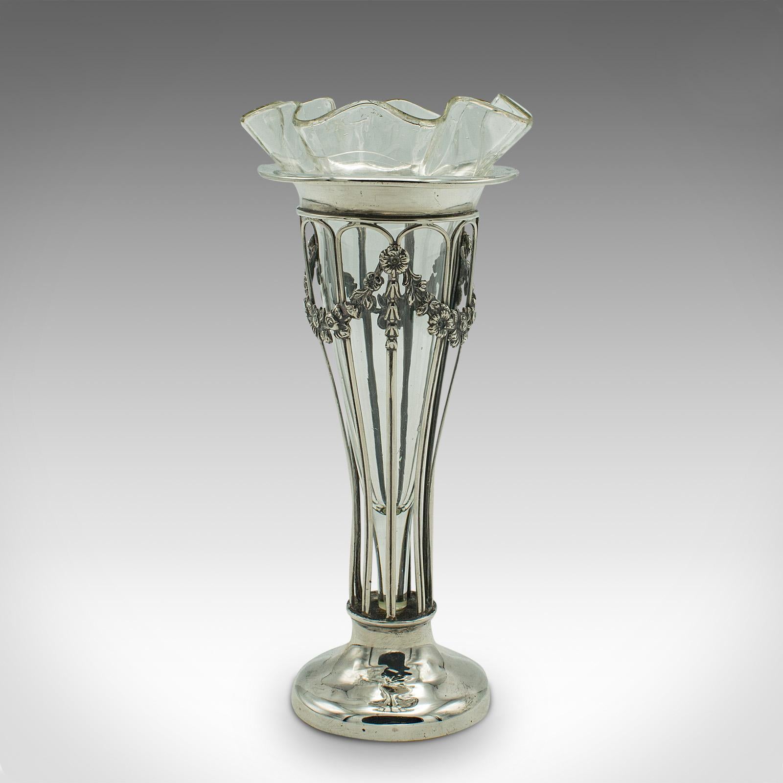 This is a small antique stem vase. An English, silver and glass decorative posy vase, dating to the Edwardian period, hallmarked 1906.
 
Expressive Art Nouveau form and appealing finish to this diminutive vase
Displays a desirable aged patina and