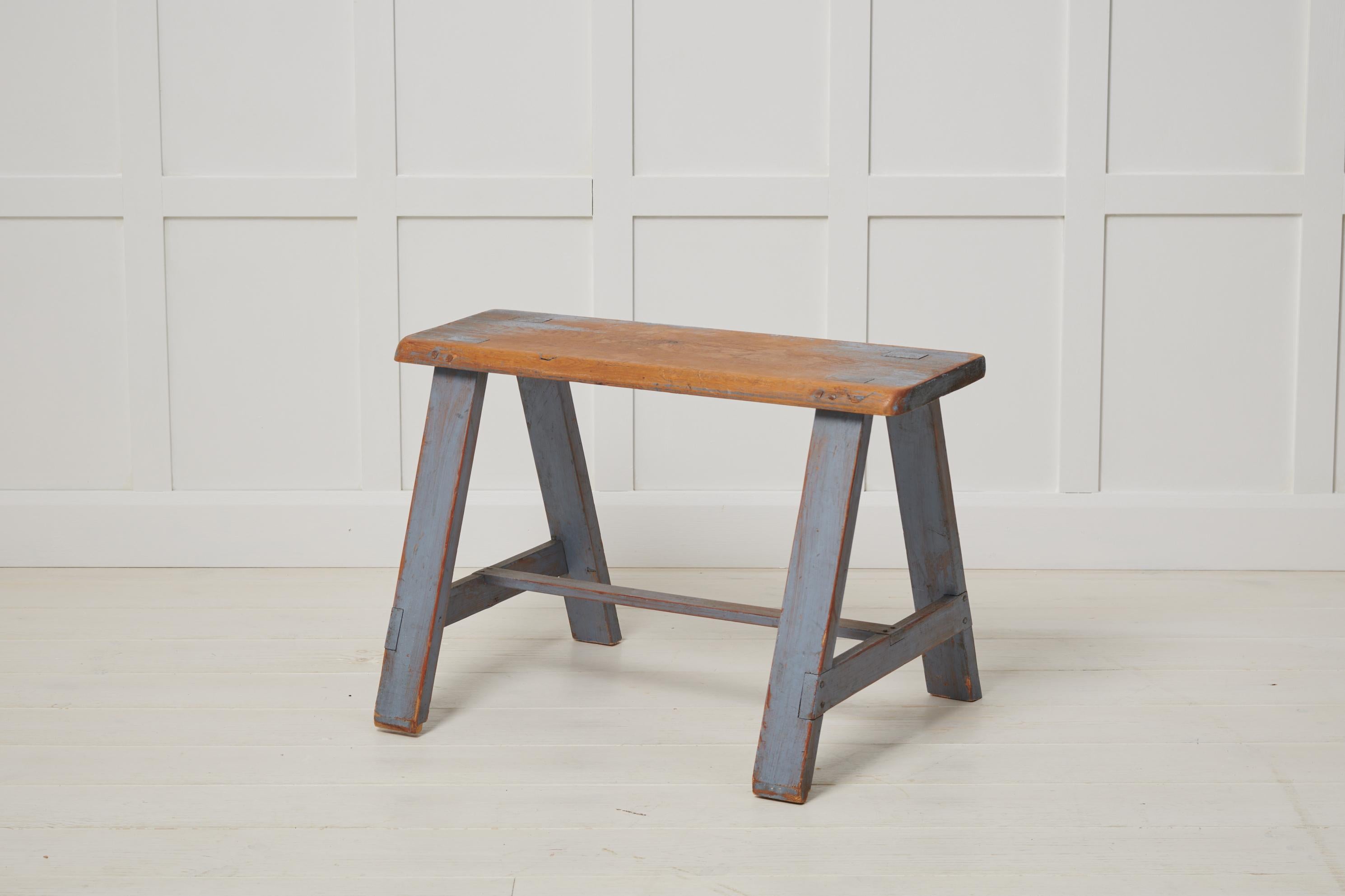 Small antique Swedish bench in folk art. The frame is made by hand in solid Swedish pine. The original light blue paint has genuine distress and patina after use which lets the pine underneath show in places. The bench was made in northern Sweden